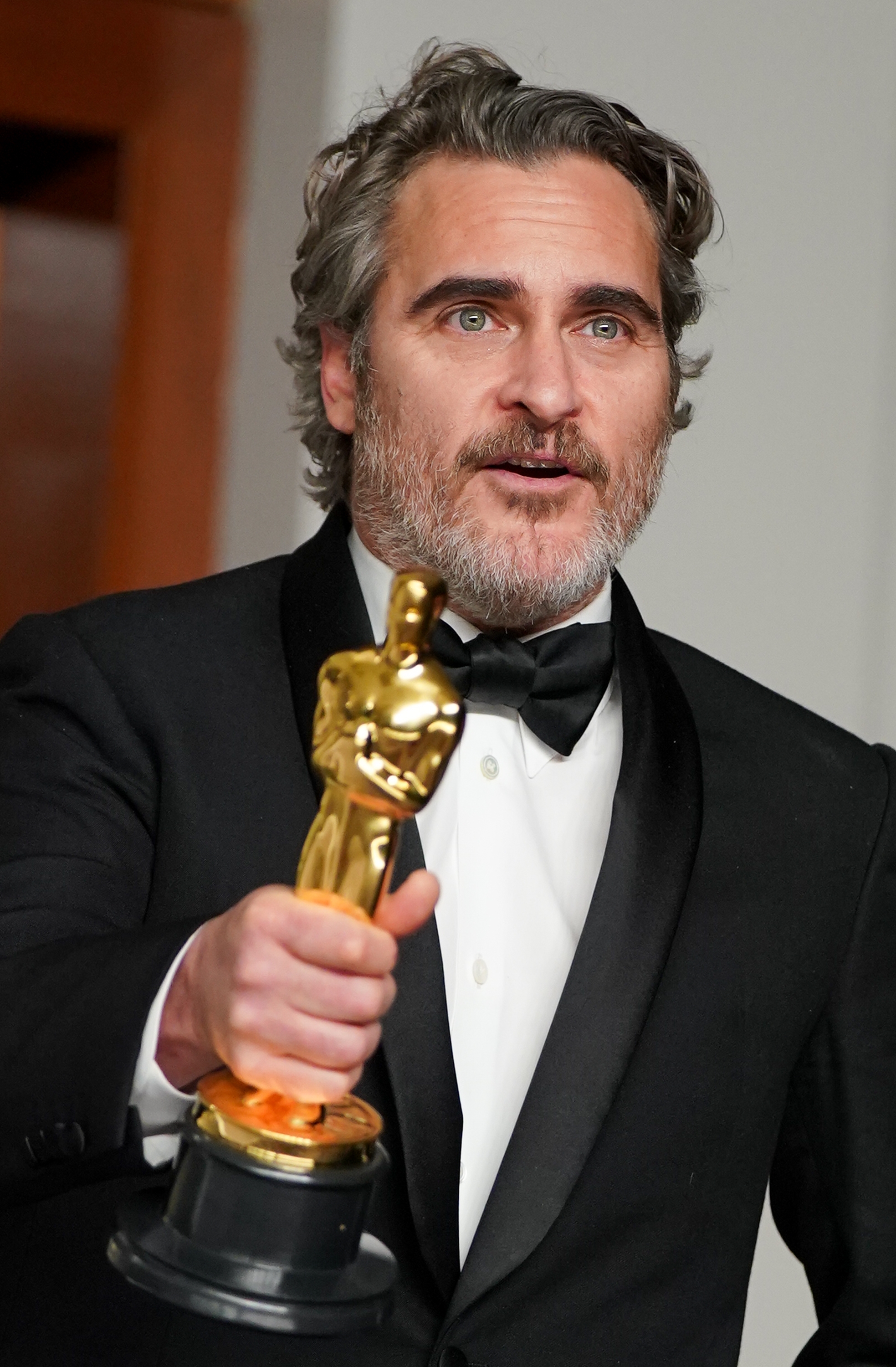Actor successful  a tuxedo holding an Oscar statuette, gesturing portion    speaking