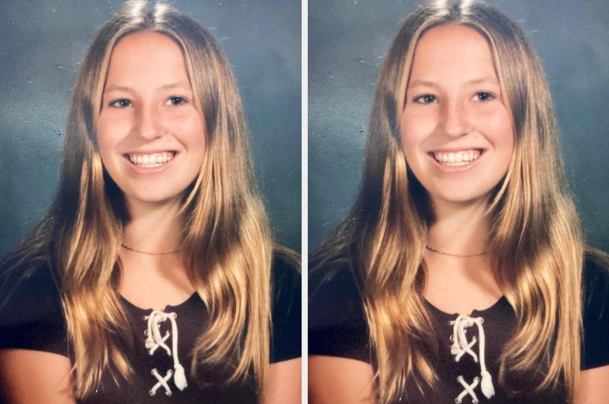 A man smiles while embracing a child wrapped in a blanket, both standing on a rocky beach