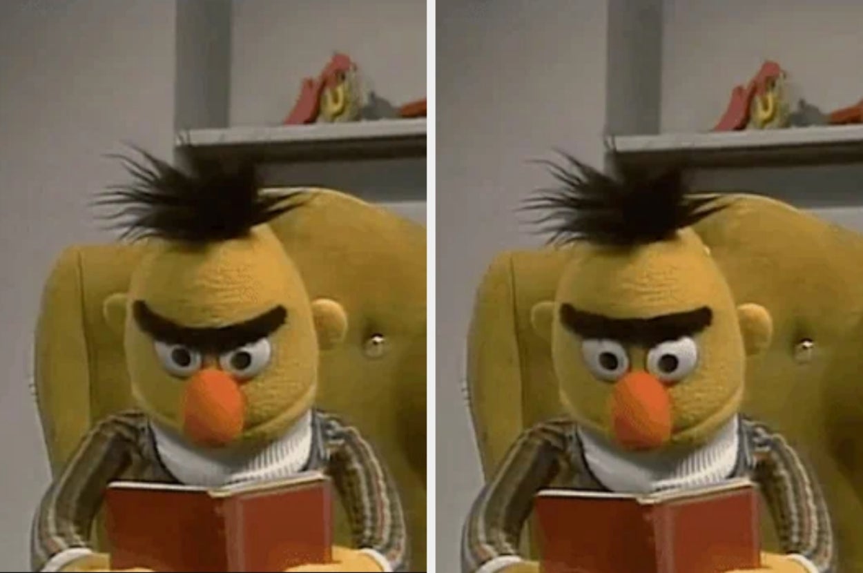 Bert, a puppet from Sesame Street, looks surprised while reading a book in an armchair