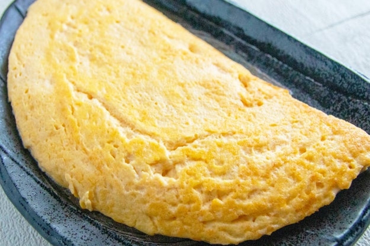 黒い皿に乗ったふわふわの出汁巻き玉子。