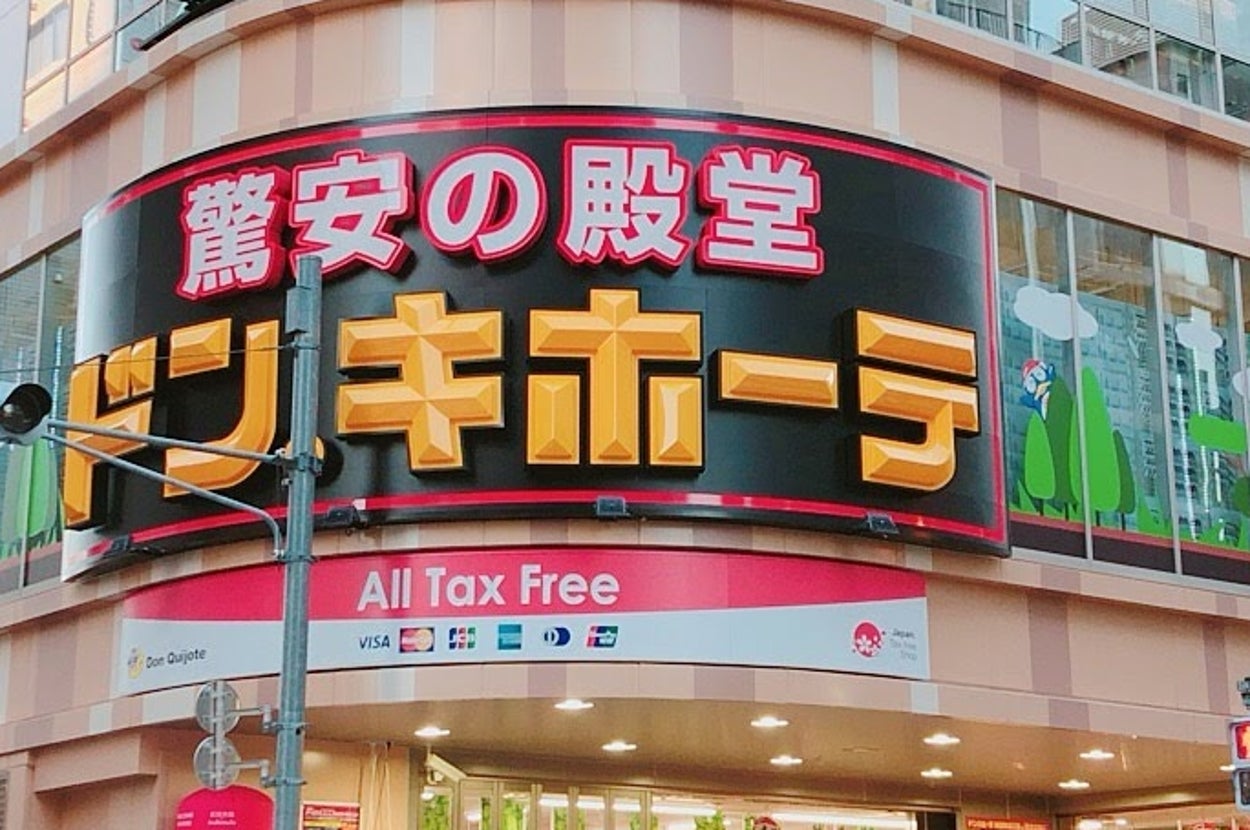 多くの人々が歩いている賑やかな交差点の角に立つ大きなドン・キホーテの店舗。