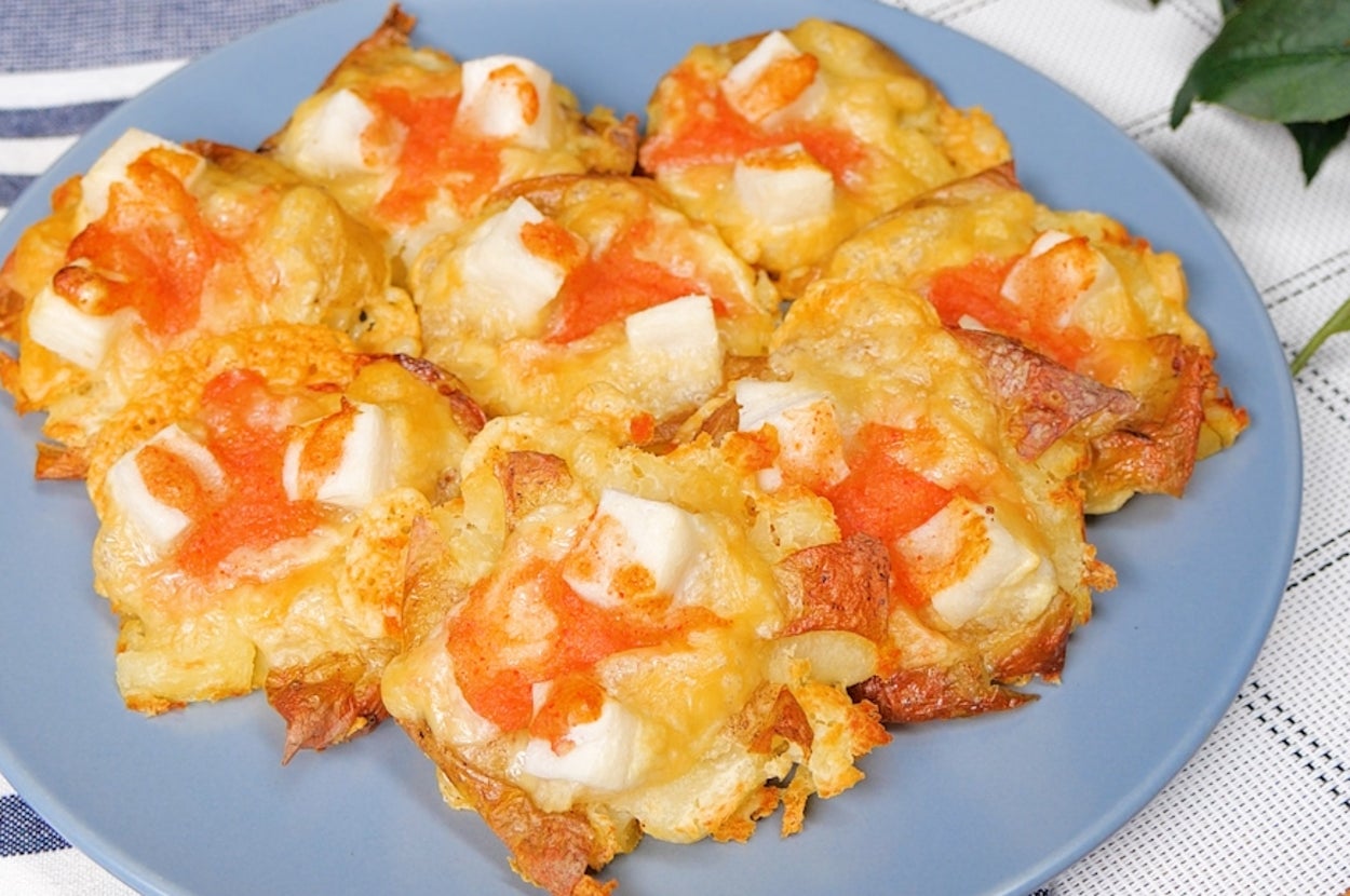 青い皿に乗った焼きチーズとトマトのアペタイザーがテーブルに置かれている。