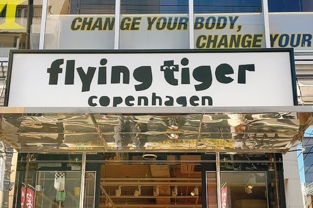 店の入口に「flying tiger copenhagen」の看板がある。背景に「CHANGE YOUR BODY, CHANGE YOUR LIFE」の文字が見える。