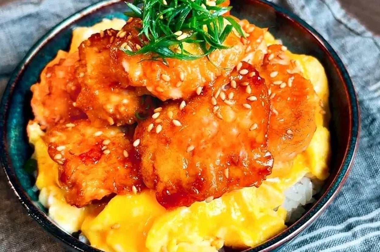 おいしそうな唐揚げ丼。から揚げはご飯とふわふわ卵の上に乗り、上には刻みネギとゴマが飾られている。