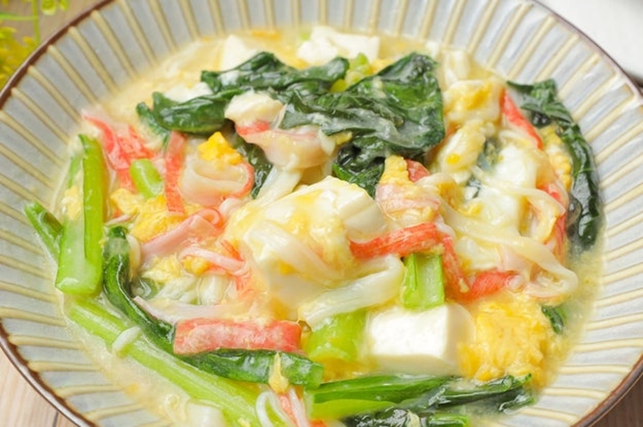 皿に盛られた野菜とカニ棒の入ったクリームシチュー。