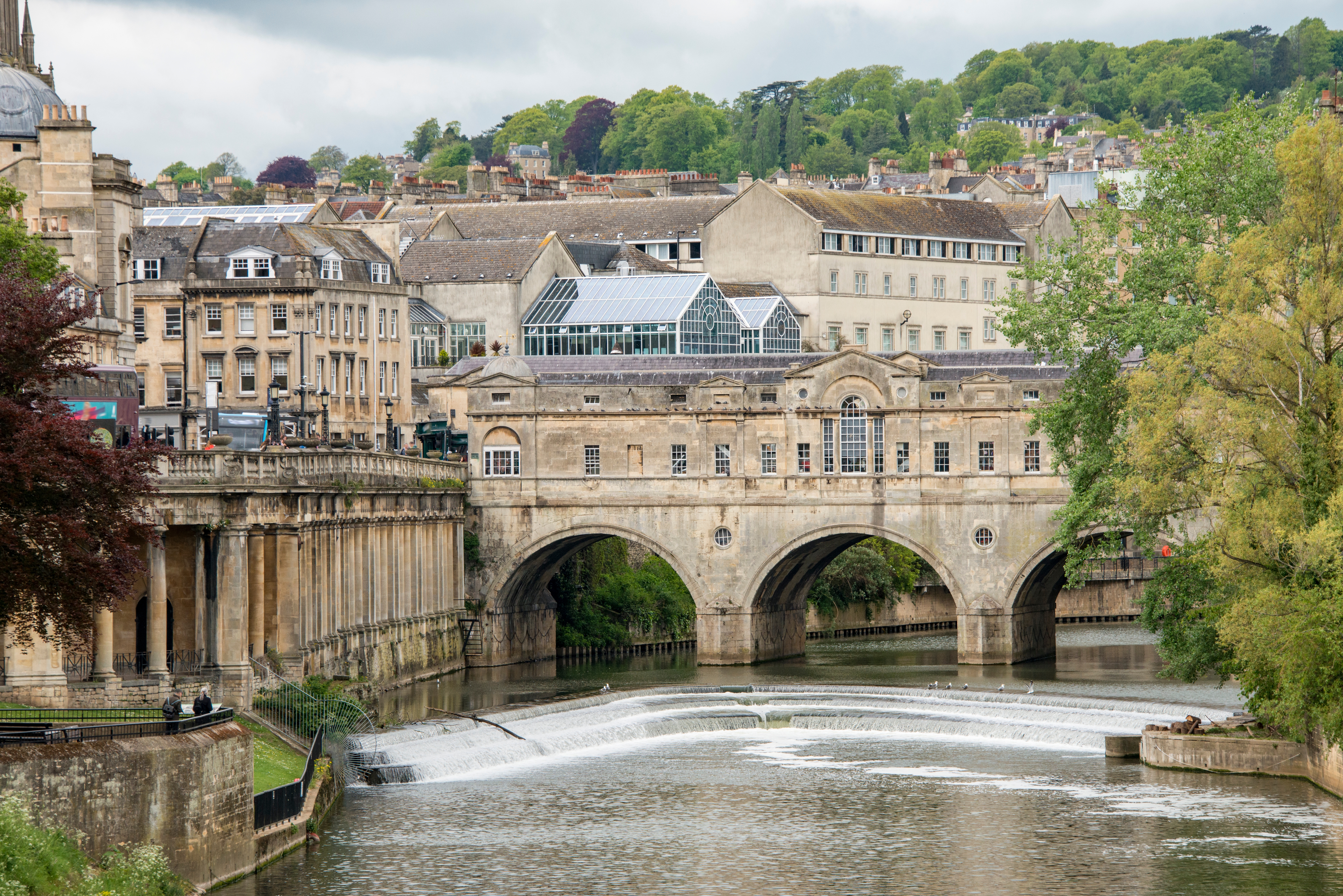 Historic chromatic span with arched windows spans a stream successful a picturesque town, surrounded by greenery and classical architecture