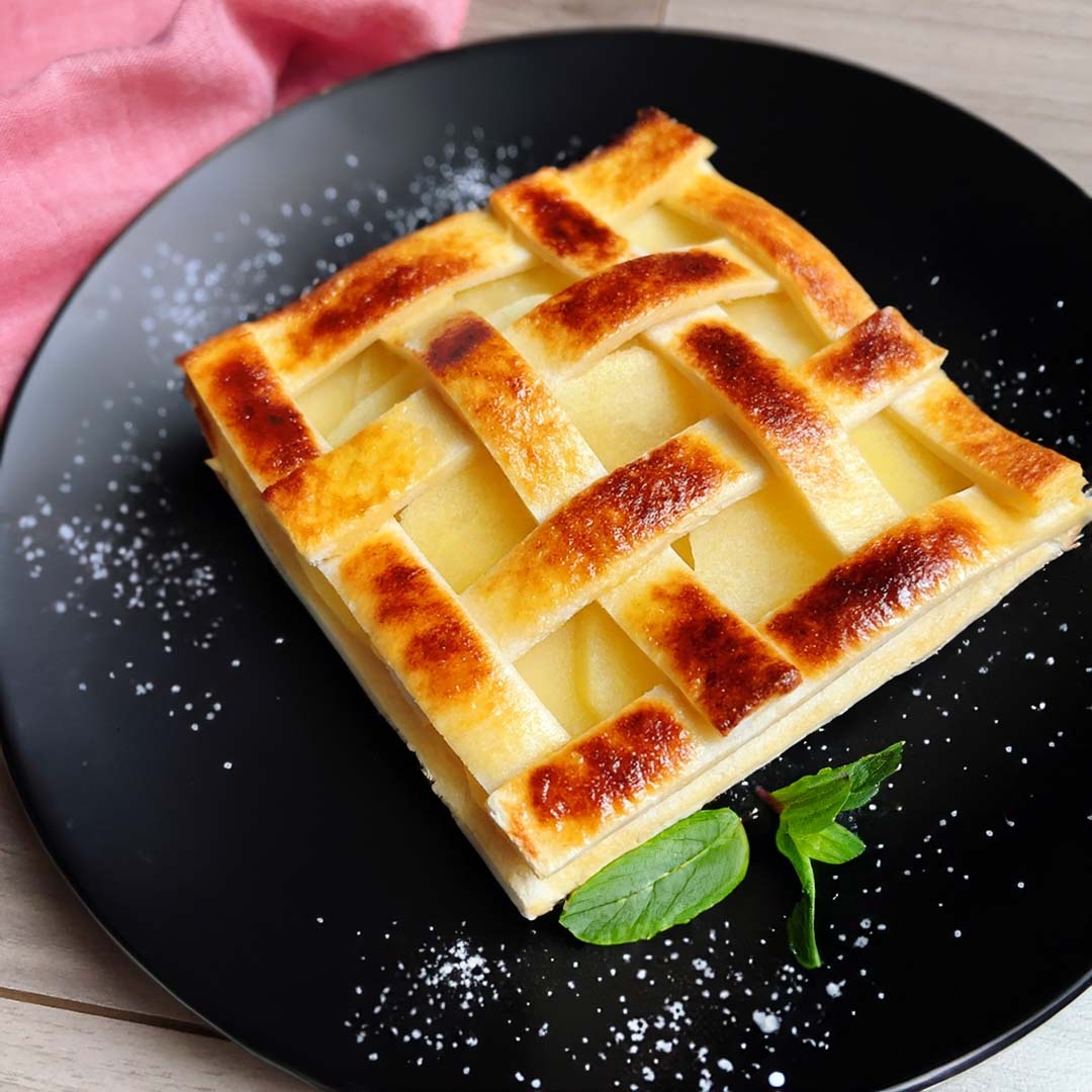 焼き菓子のパイ、編み込みの生地とミントが添えられた皿にのせられています。