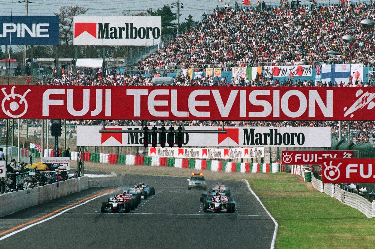 フジテレビのロゴが掲げられた1998年のF1日本GP決勝のスタートライン（三重・鈴鹿サーキット）＝時事