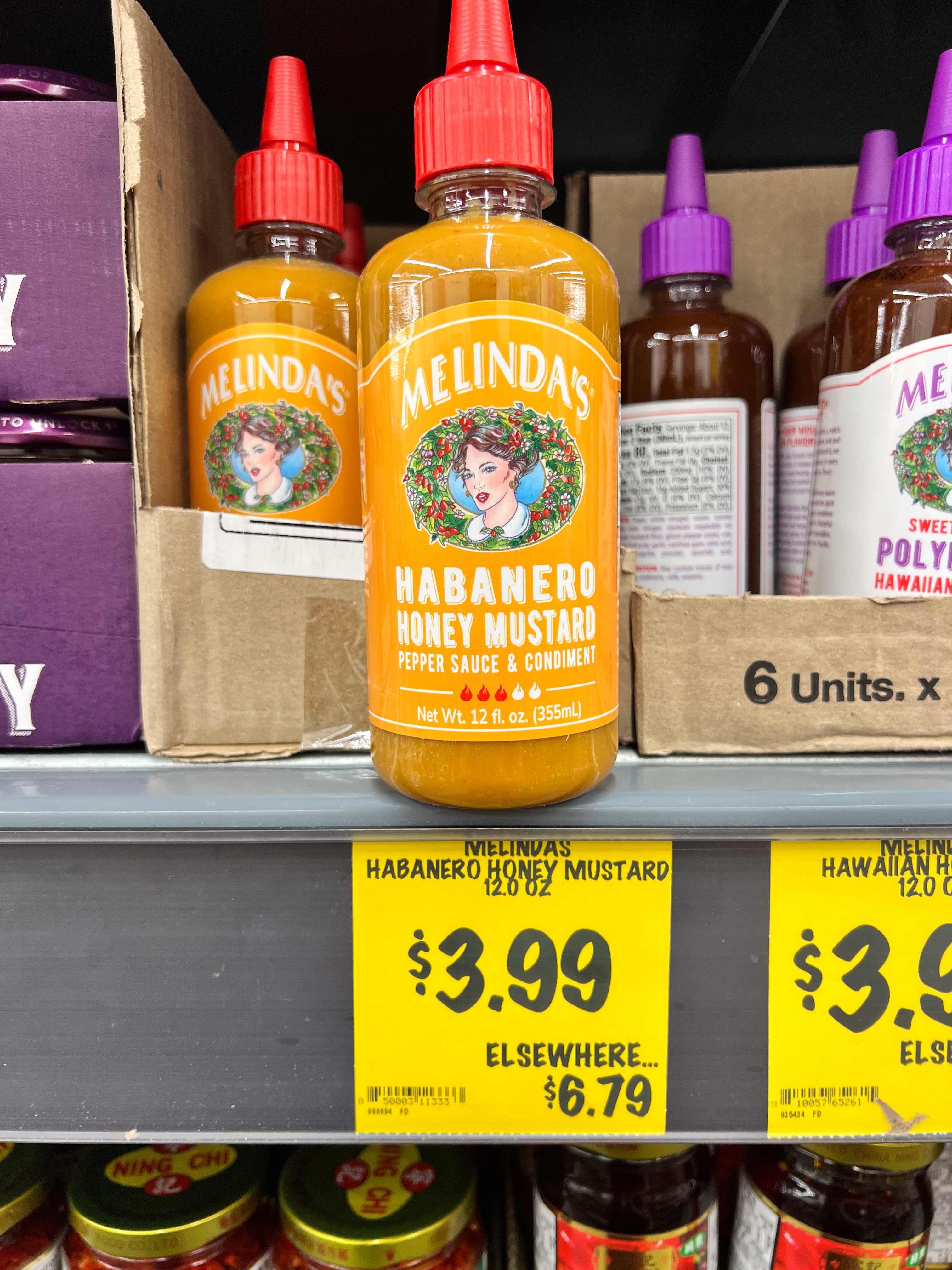 Melinda's Habanero Honey Mustard bottles displayed connected a store support with a terms tag showing $3.99 compared to $6.79 elsewhere