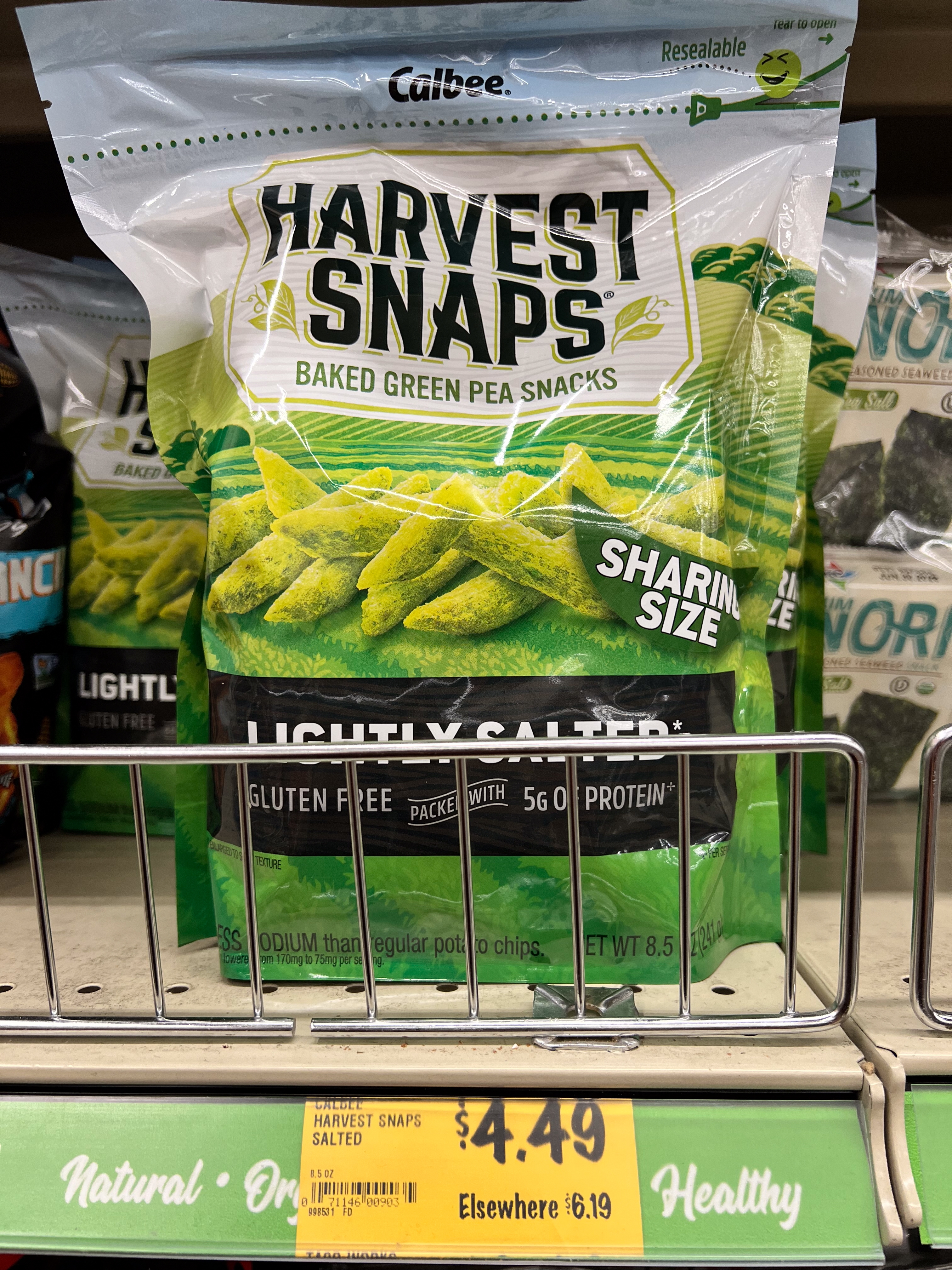 Bag of Harvest Snaps baked greenish pea snacks connected a store shelf, labeled "lightly salted" and priced astatine $4.49