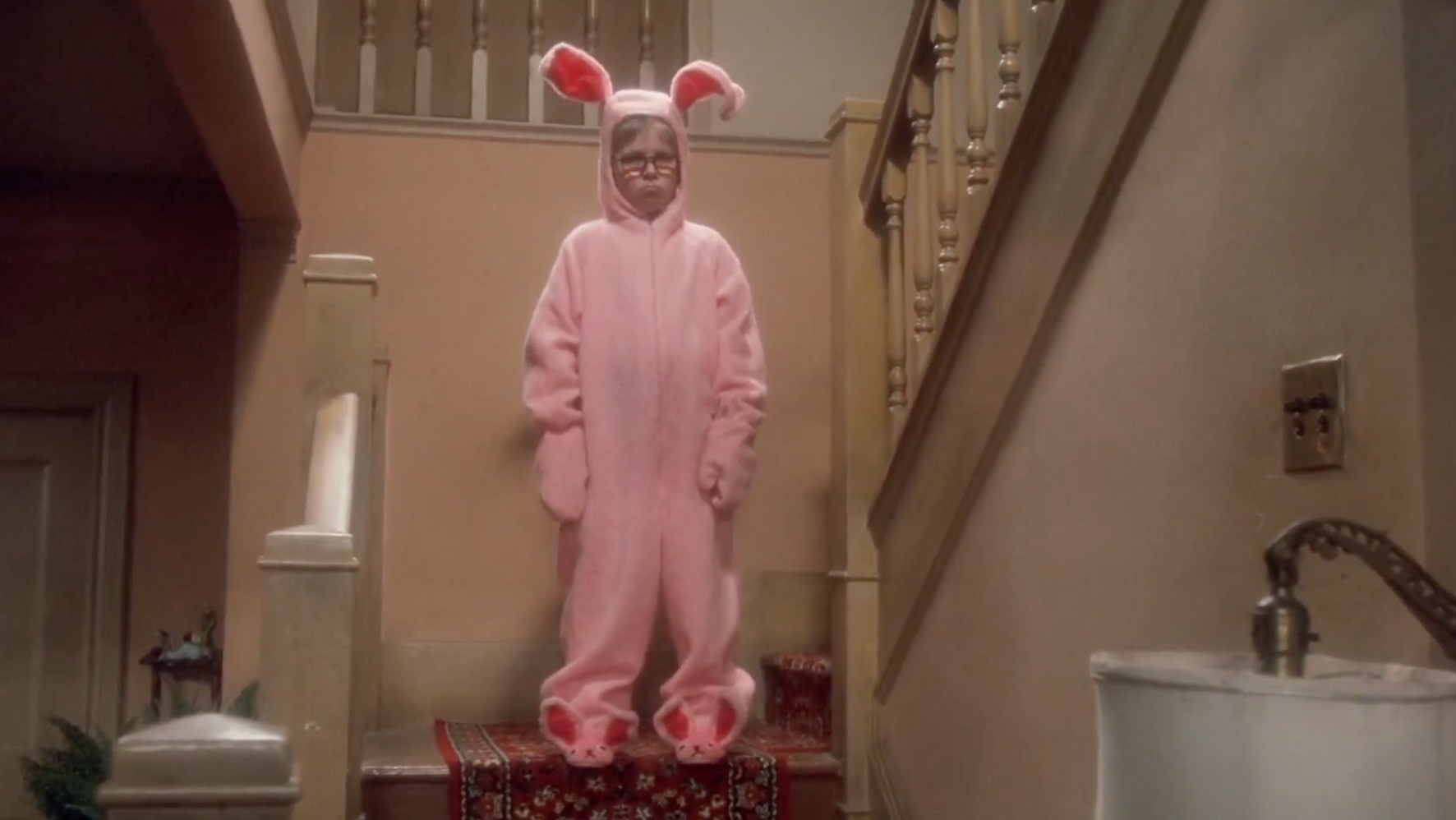 Child successful  pinkish  bunny costume stands connected  stairs successful  a home, looking forward
