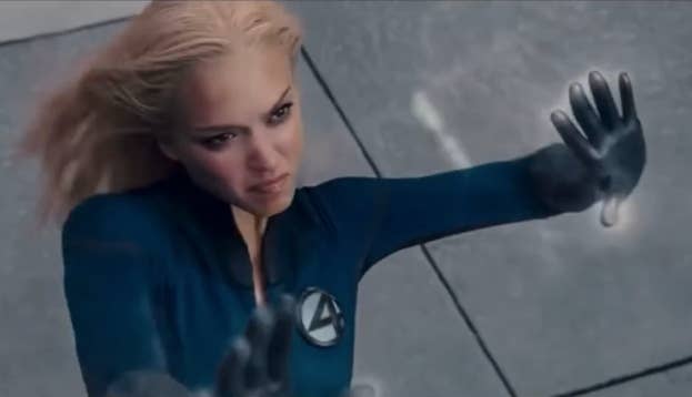 jessica alba in a superhero suit with an "4" emblem, appearing to use her powers, pushing against an invisible barrier