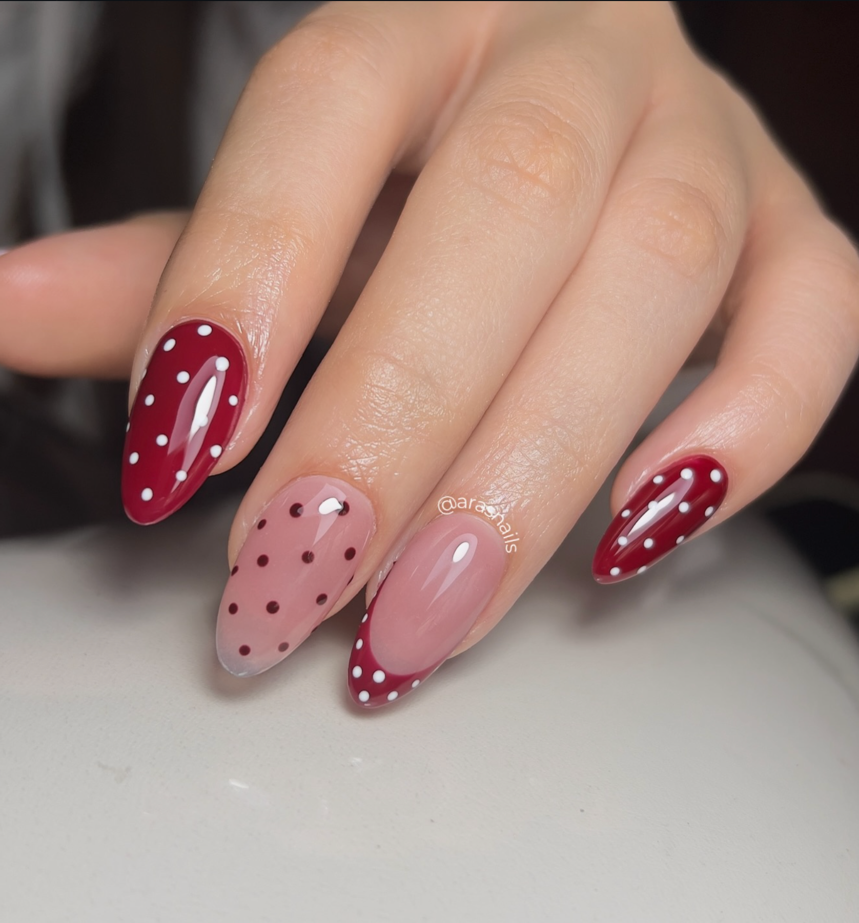 Mano con uñas manicura francesa, cada uña con puntitos y decoración única