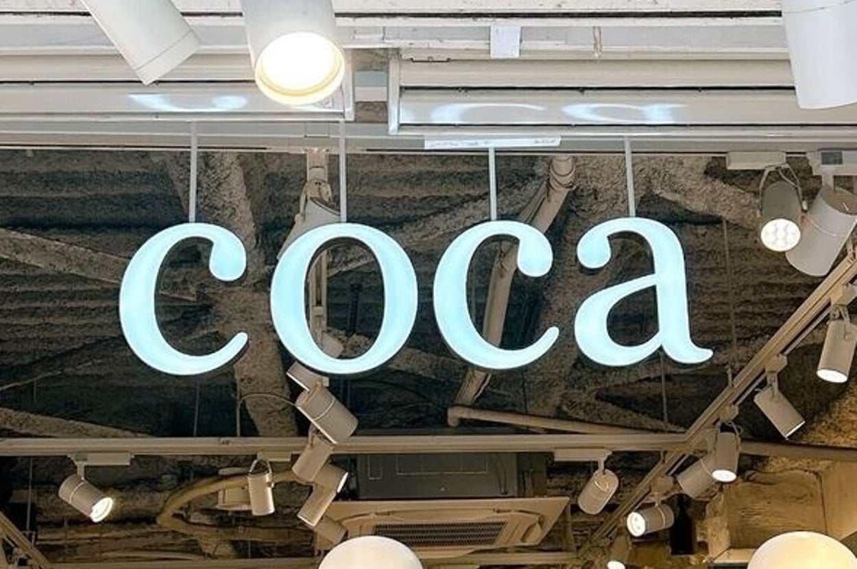 お店の入り口に「coca」と書かれたネオン看板が飾られている。展示されているマネキンが数体並ぶ。
