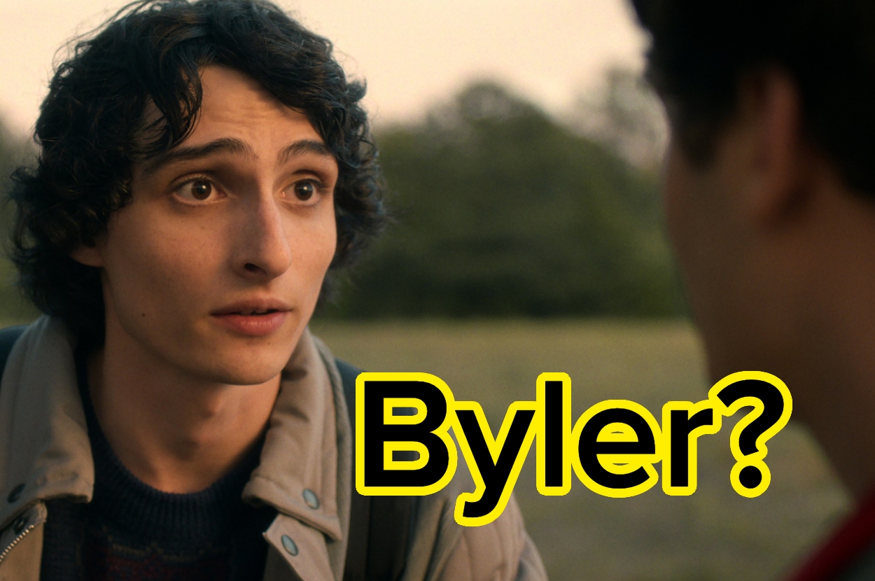 Person with a surprised expression talking to another person, outdoors, with the text "Byler?" in bold yellow