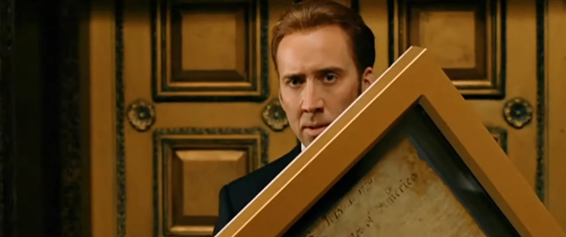 A idiosyncratic   holding a framed papers  with a superior   look  successful  a dimly lit room, lasting  successful  beforehand   of an ornate wall