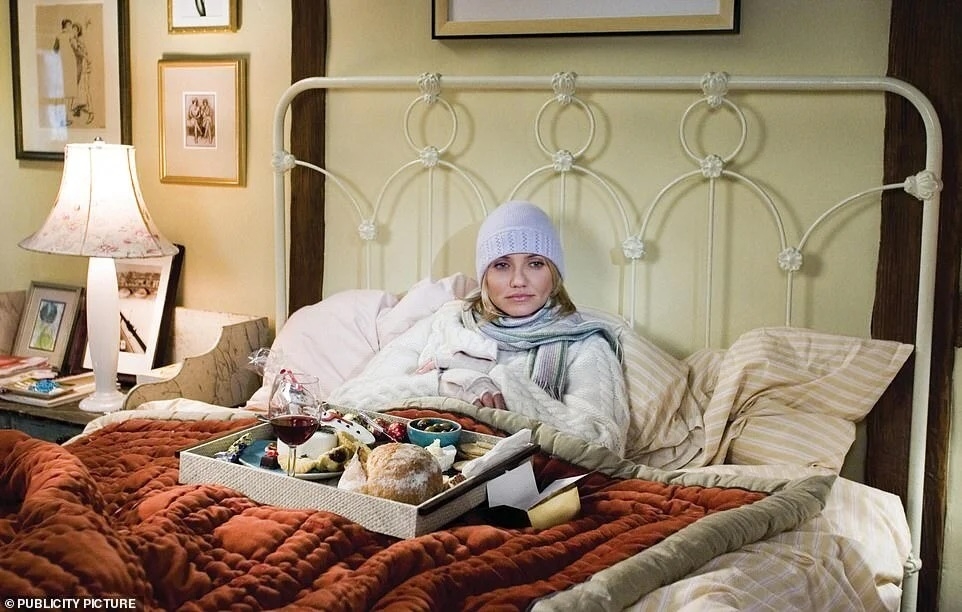 Person successful  a cozy furniture  with a beanie and scarf, surrounded by pillows. A tray with nutrient  and vino  is connected  the bed, creating a lukewarm  ambiance