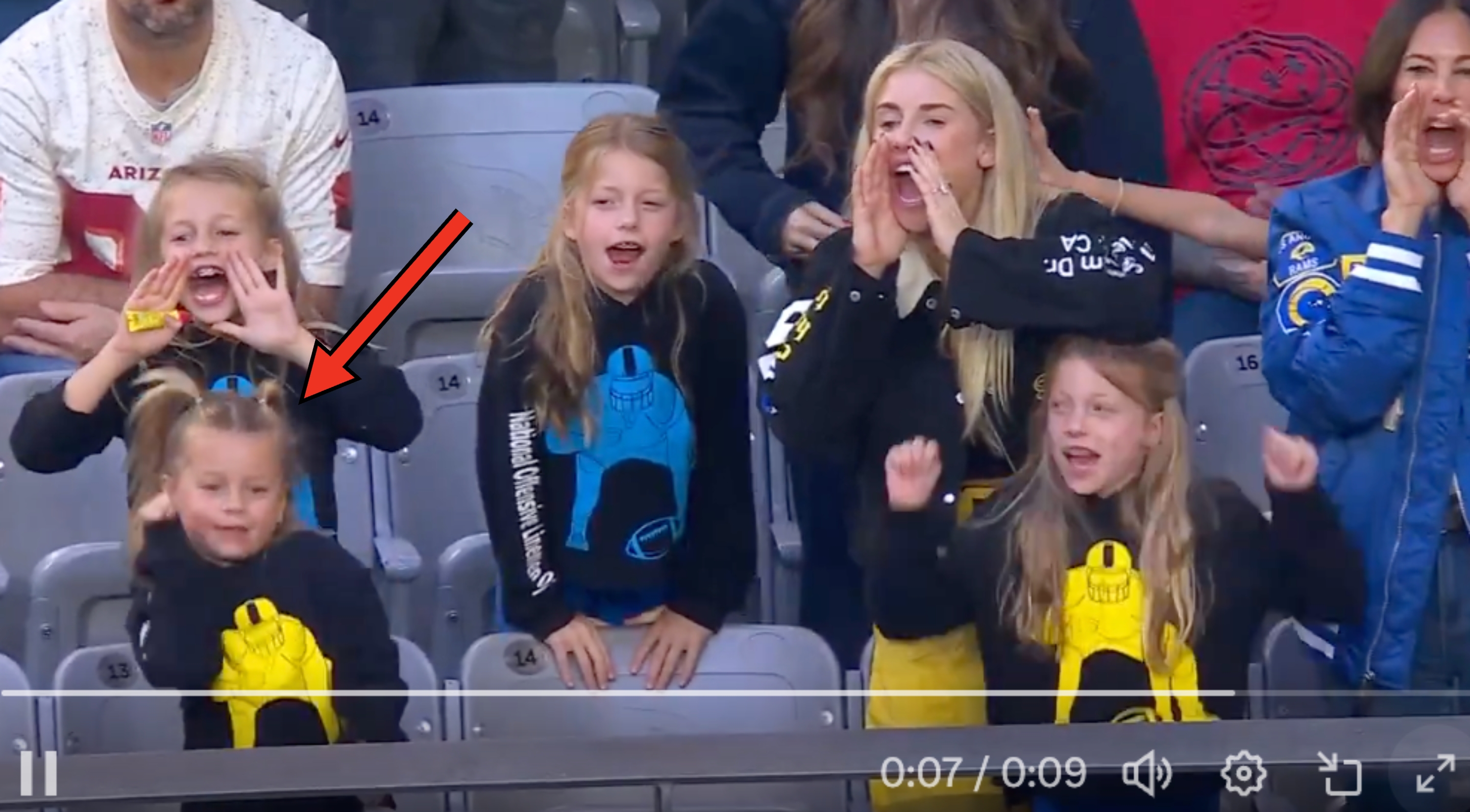 女の子がスポーツスタジアムで応援中、元気に声を上げている様子。