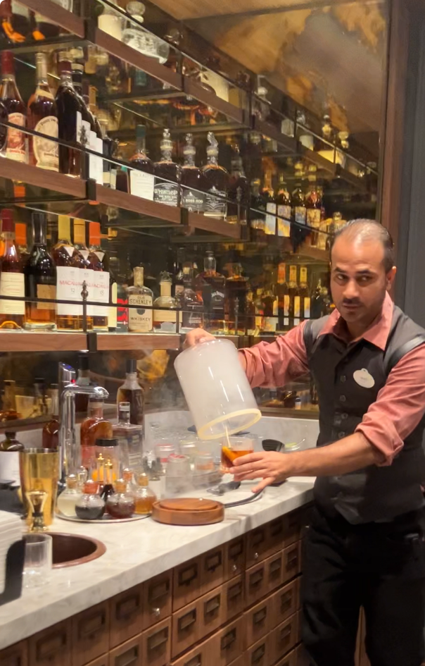 Bartender creating a smoke-infused cocktail astatine  a well-stocked bar, with bottles of assorted  spirits connected  shelves behind