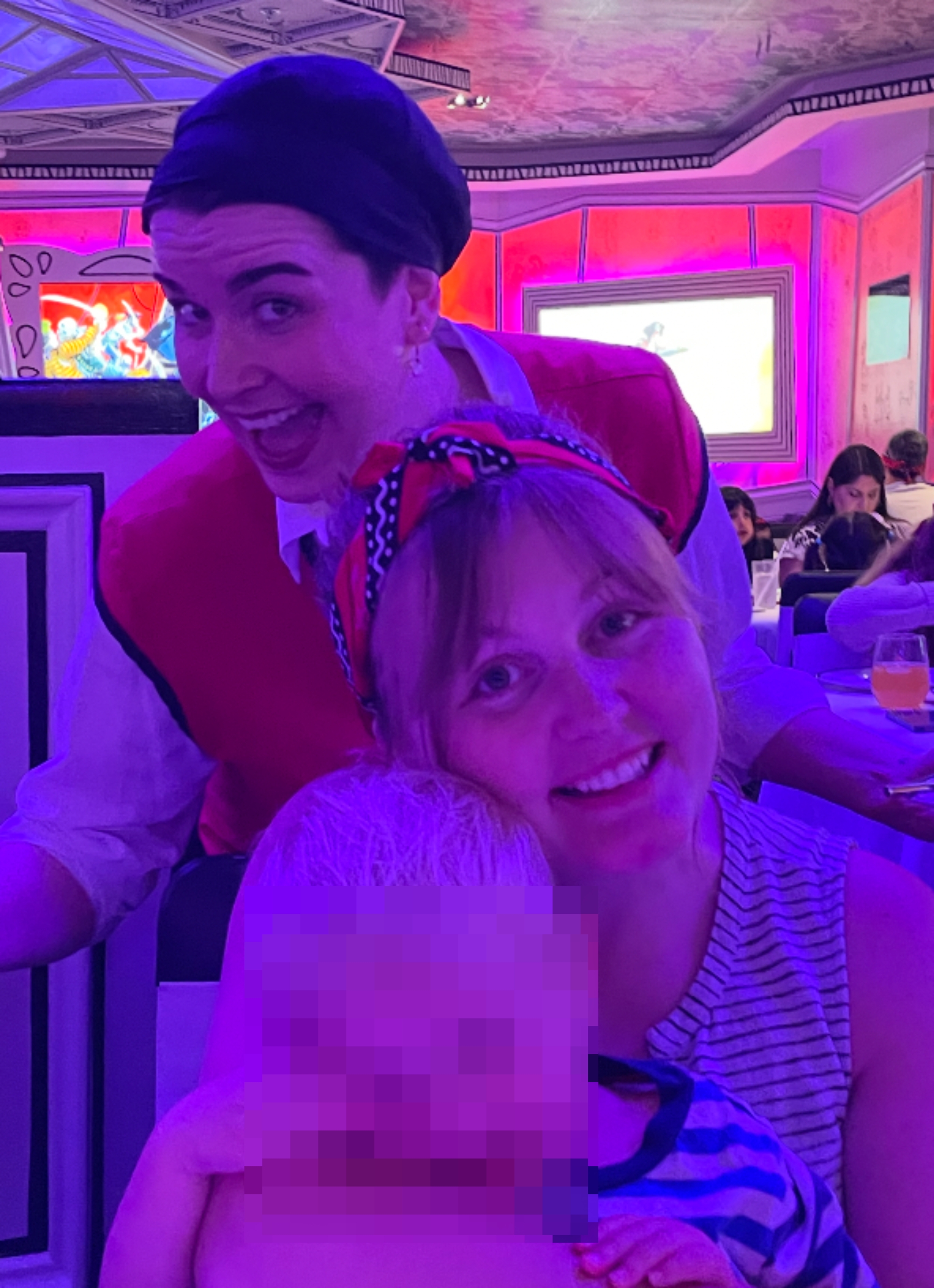 Two smiling adults, 1  successful  a beret and vest, with a child. Indoor mounting  with an attendee assemblage  successful  the background