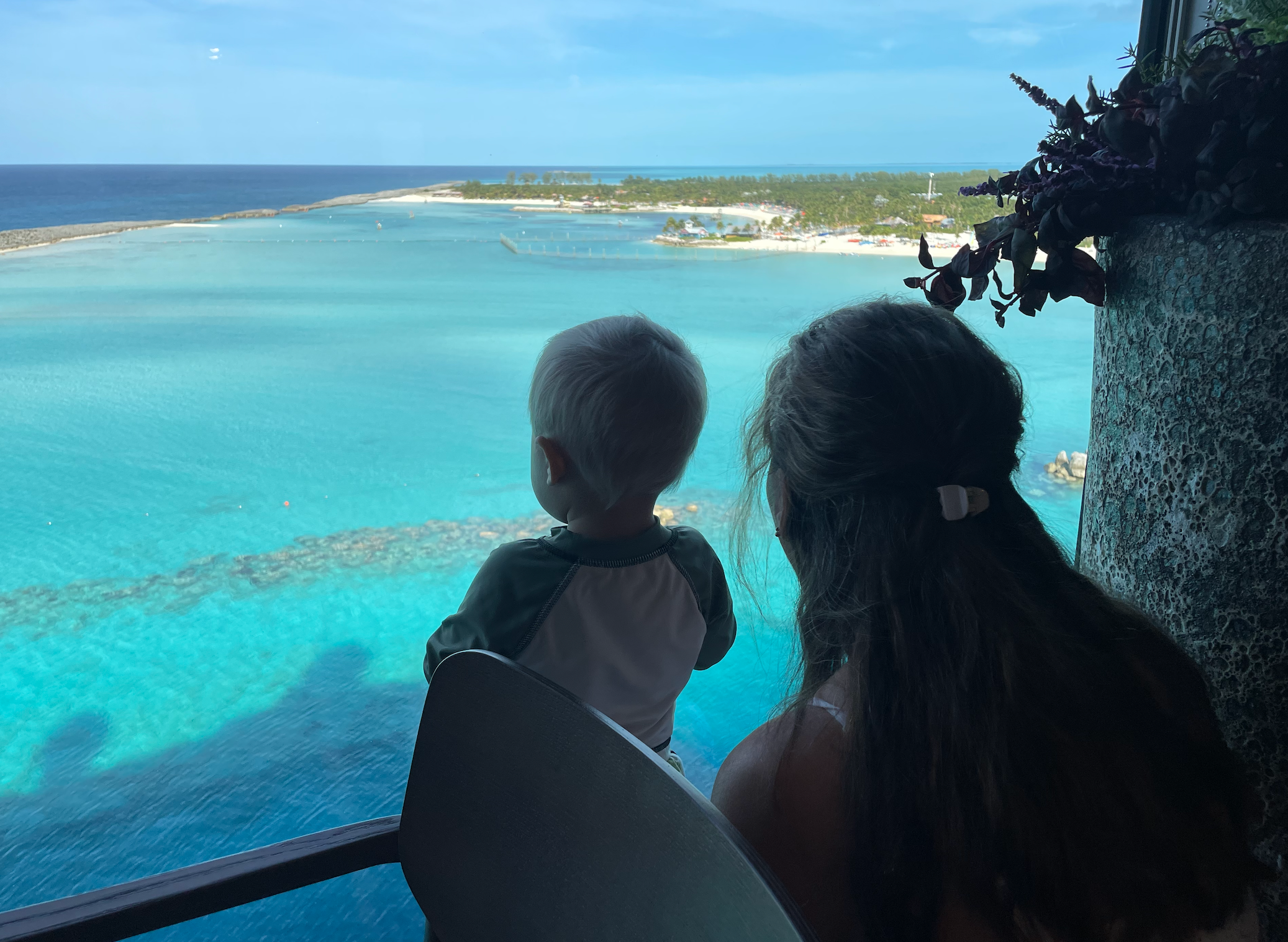 A pistillate   and kid  look   retired  implicit    a peaceful water  from a precocious   vantage point