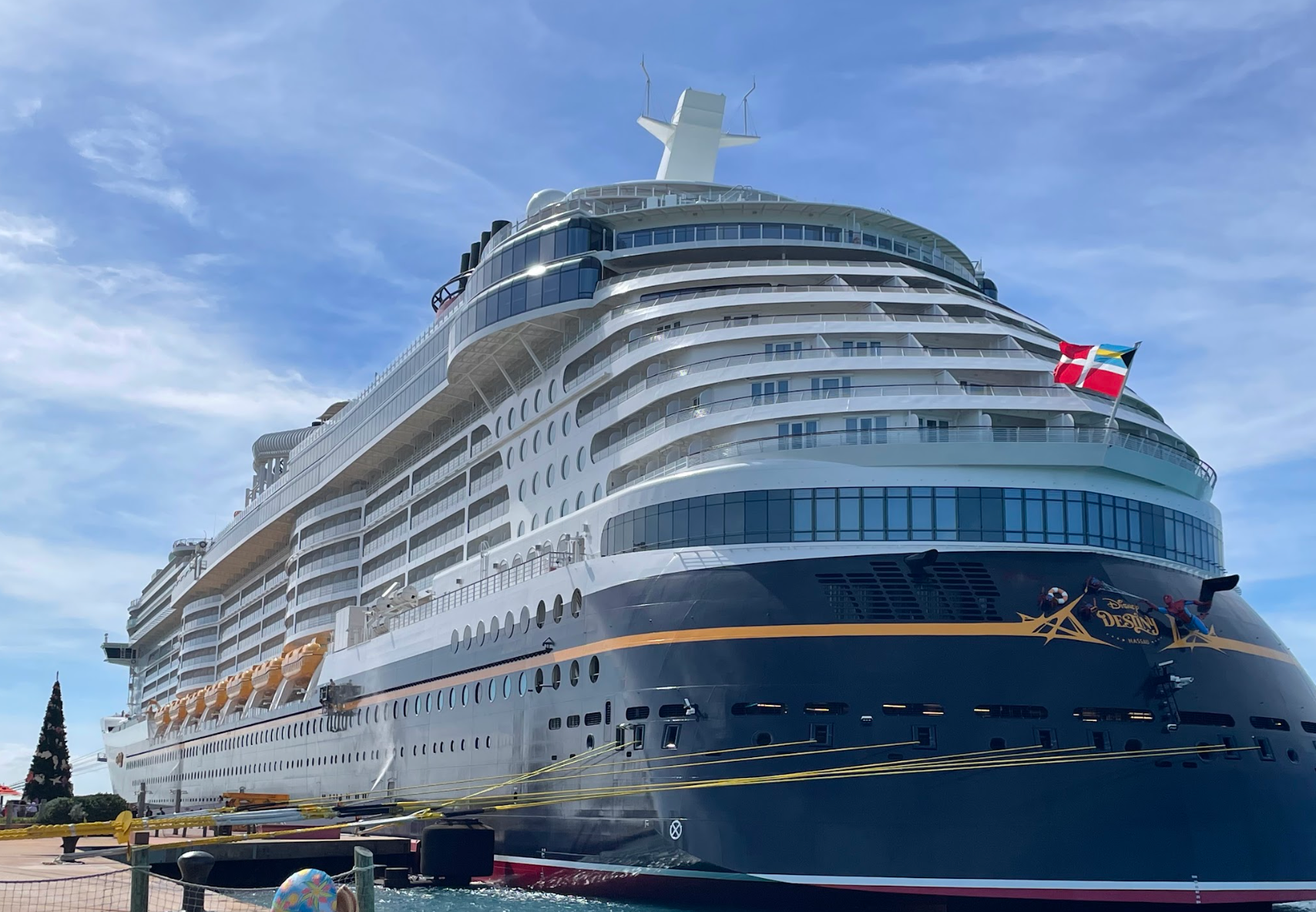 A ample  cruise vessel  docked astatine  a pier against a wide   sky, displaying flags and aggregate  decks