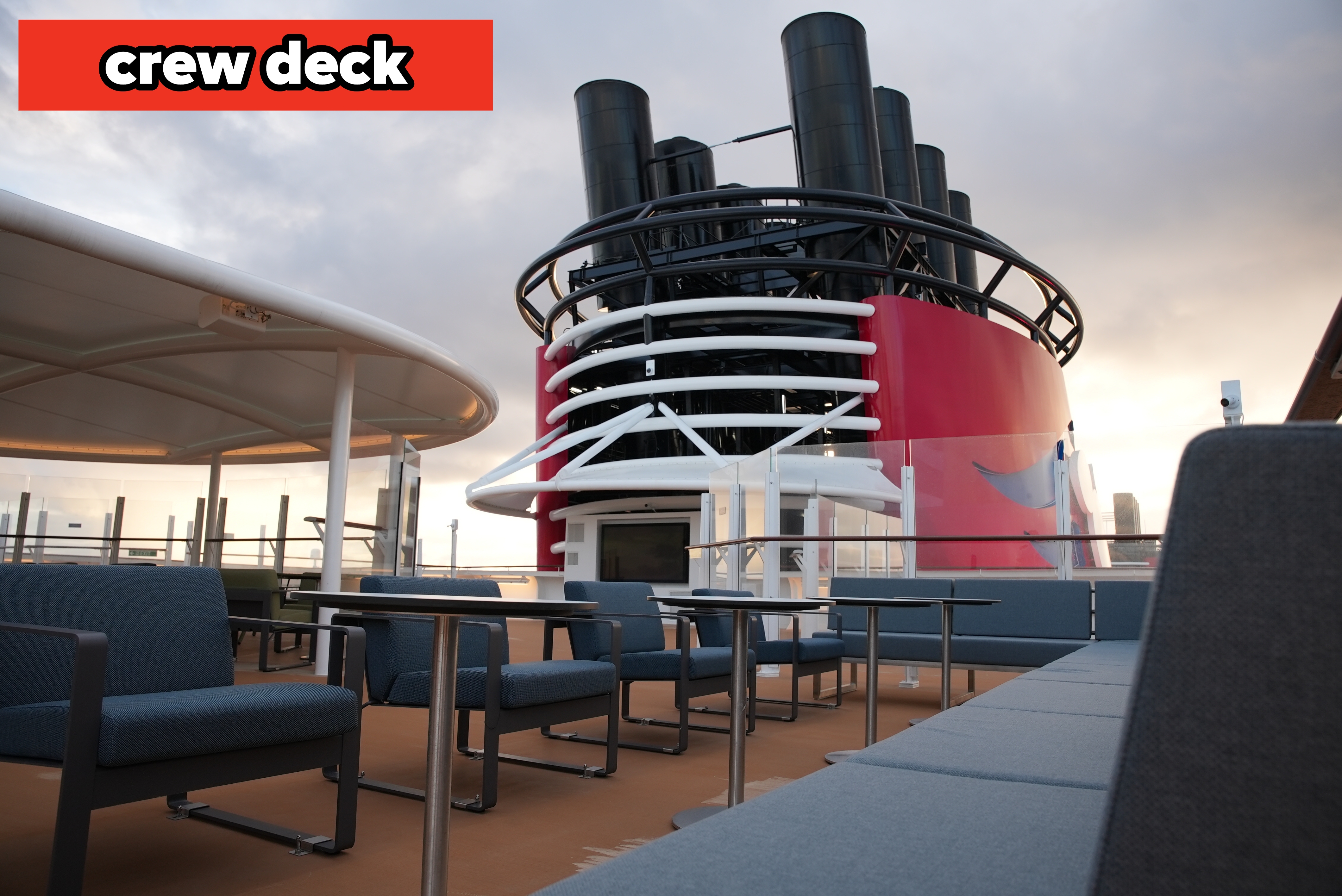 Deck presumption    with seating and a large, stylized cruise vessel  funnel successful  the inheritance  nether  a cloudy sky