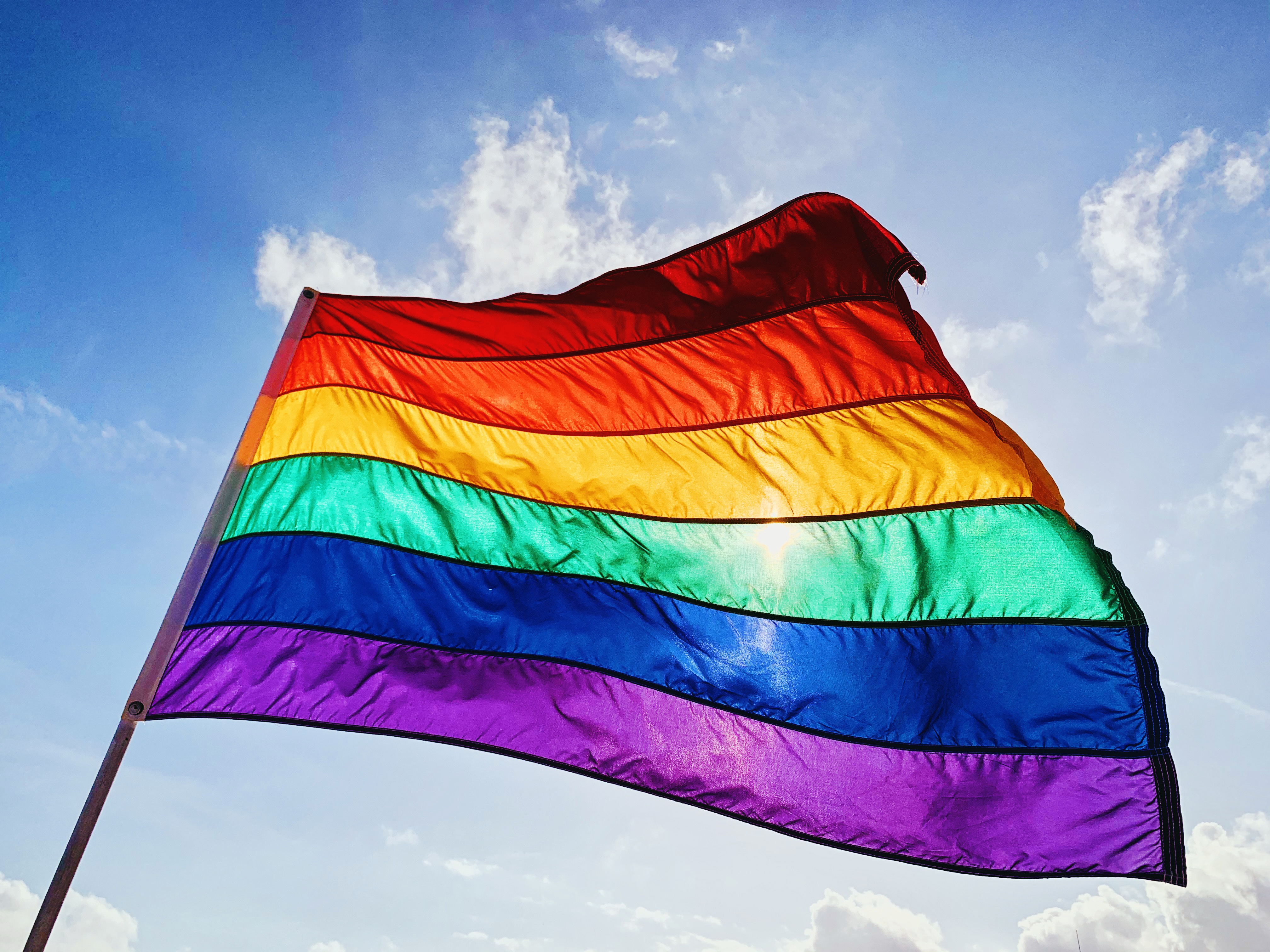 Pride emblem  waving against a wide   sky, symbolizing LGBTQ+ pridefulness  and diversity