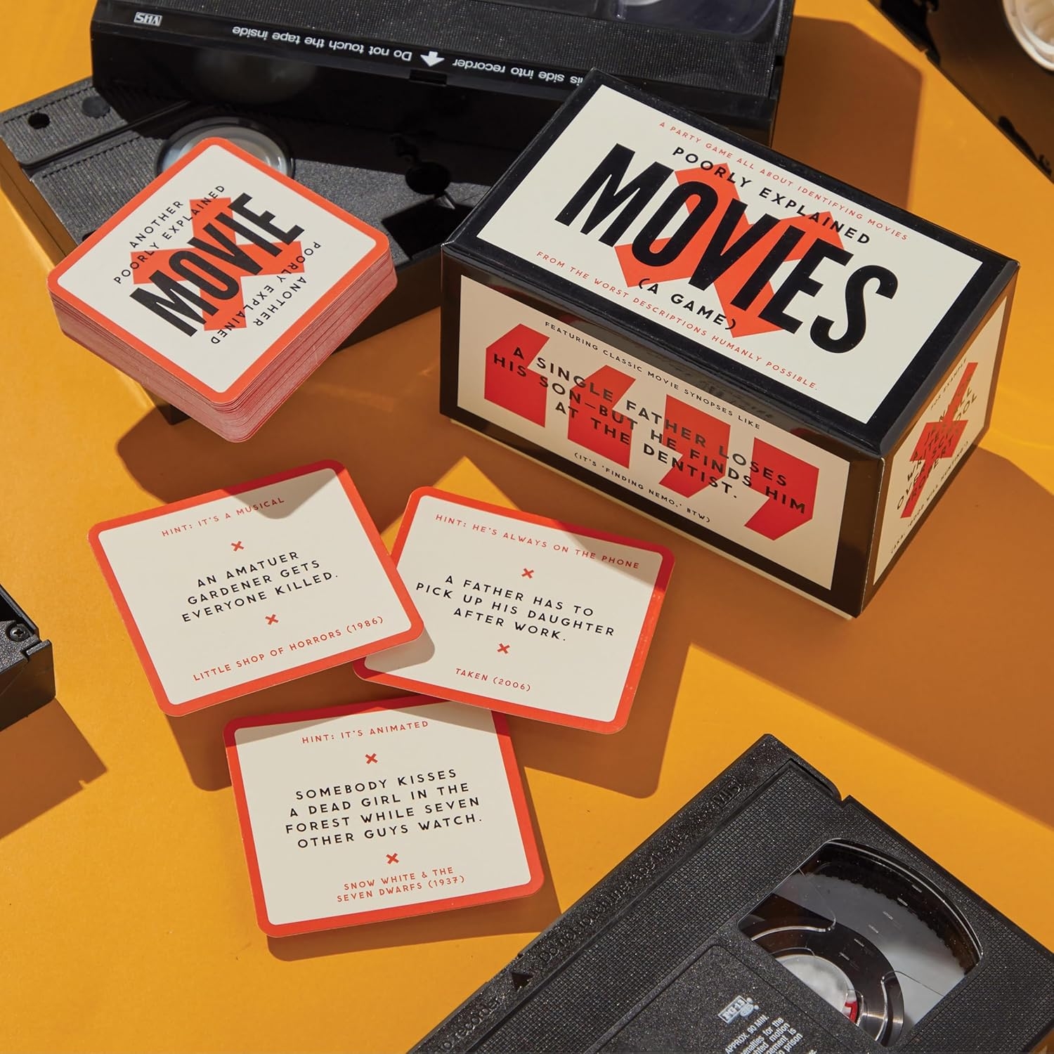 Board crippled  titled &quot;Movies&quot; with cards featuring humorous descriptions of movie   plots displayed connected  a array  with 2  VHS tapes