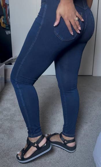 Person modeling No nonsense denim leggings and open-toe sandals from the side