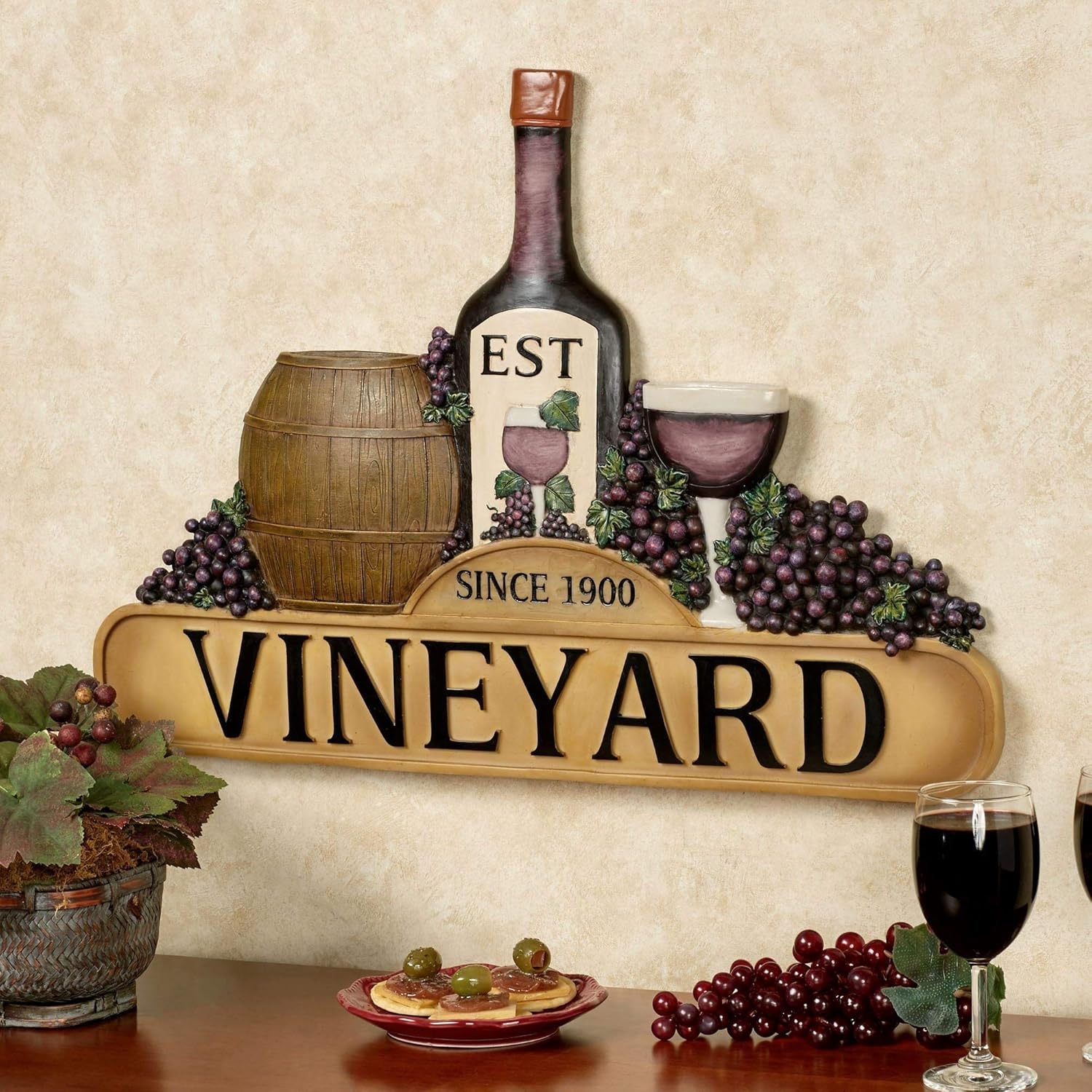 Wall decor featuring a vino  bottle, barrel, grapes, and glasses with the words "Est Since 1900 Vineyard."