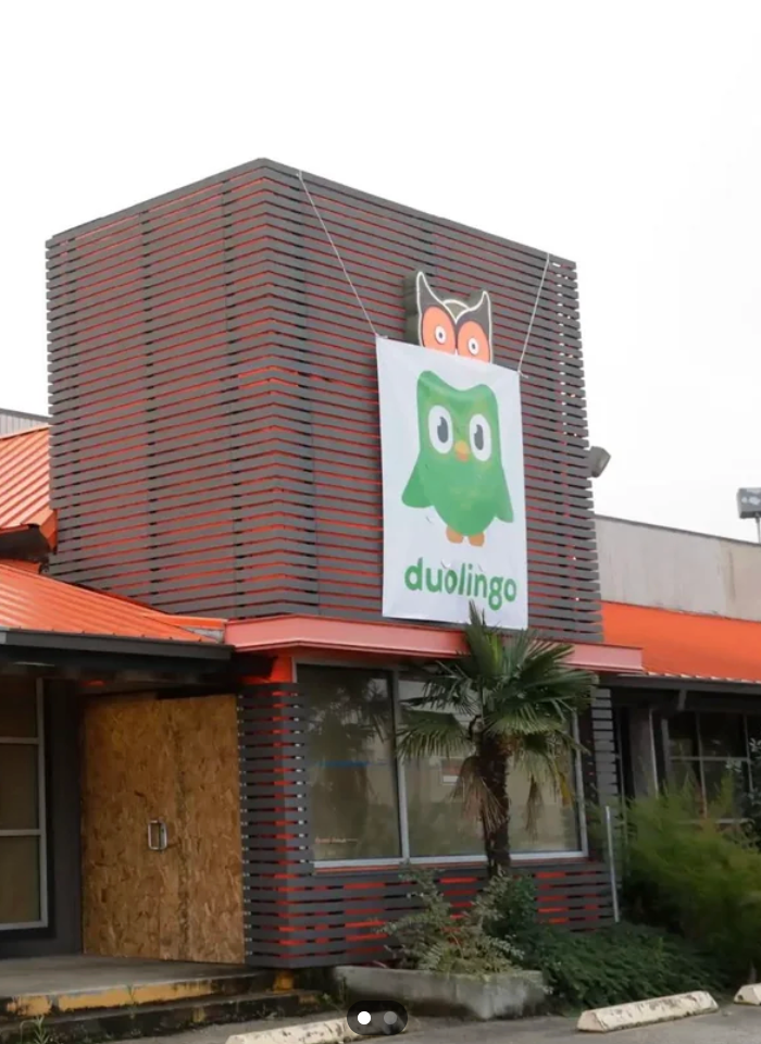 Building with a ample  Duolingo owl motion   connected  the front, featuring a woody  committee  implicit    a model   and a tiny  thenar  histrion   nearby