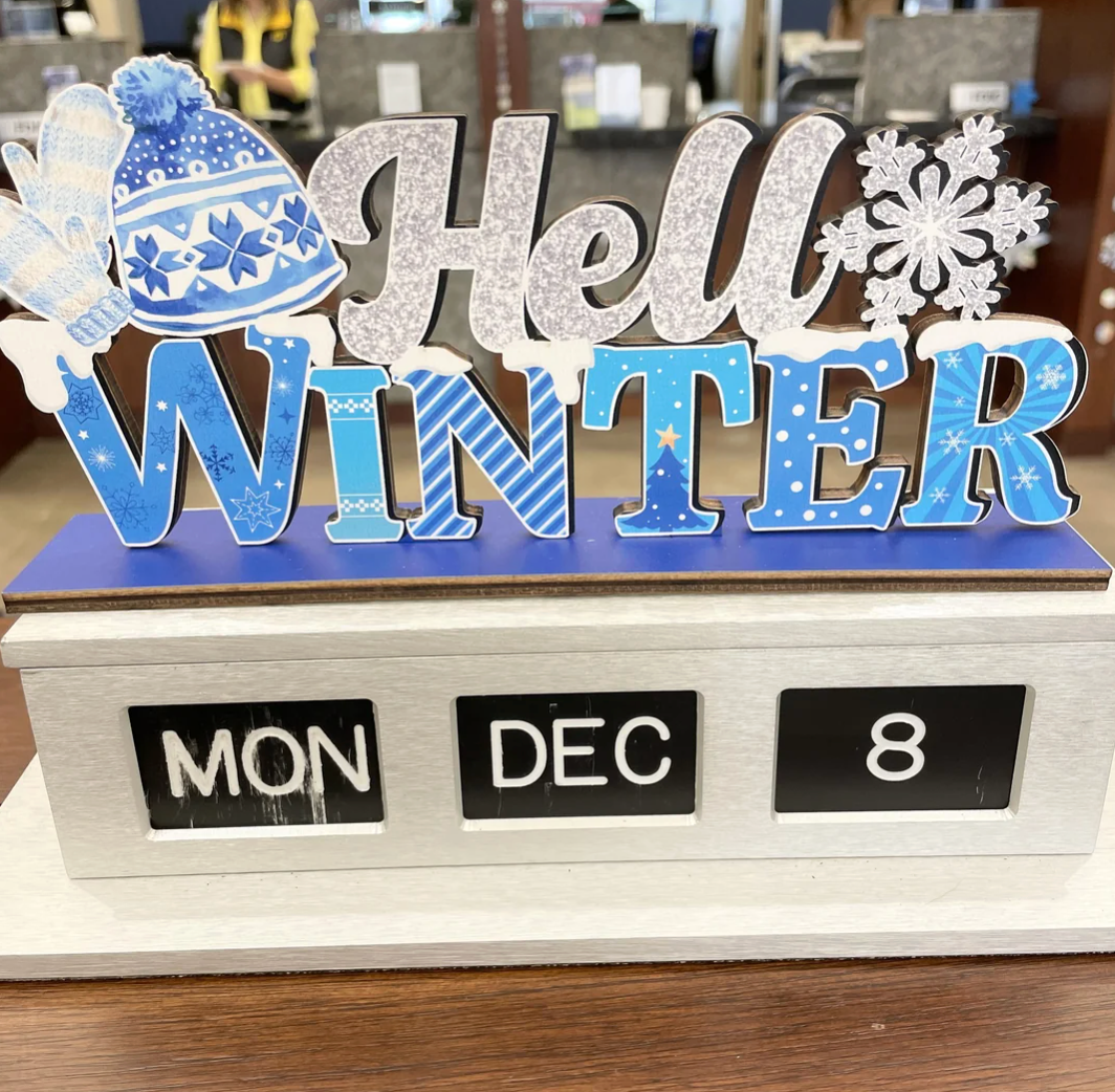 Decorative motion   reads "Hello Winter" with a snowflake and mittens, sitting connected  a table  calendar displaying "Mon, Dec 8."