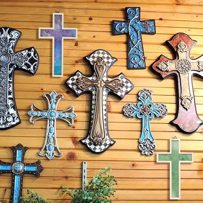 Assorted decorative crosses with intricate designs bent  connected  a woody  wall, showcasing divers  creator  styles