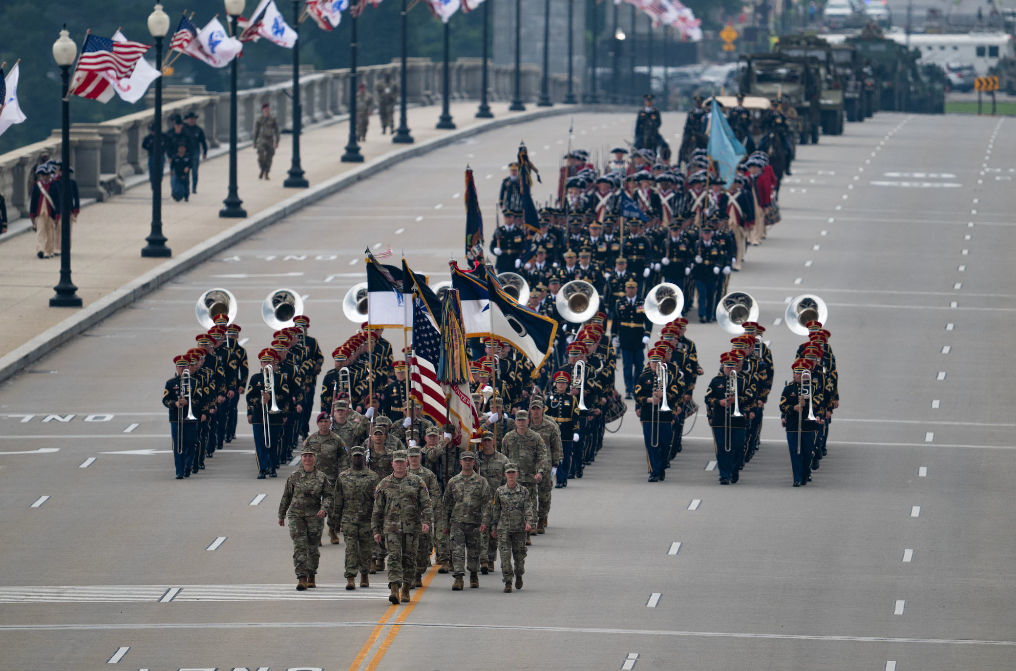 A subject parade features soldiers successful azygous starring a marching set with brass instruments connected a wide thoroughfare lined with flags