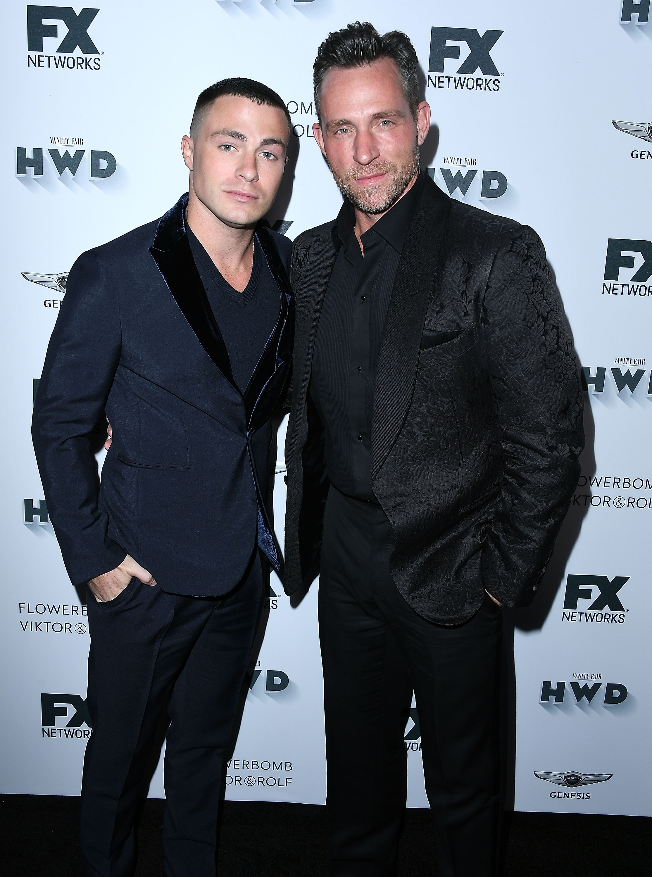 Two individuals airs  connected  a reddish  carpet successful  elegant suits astatine  an amusement  lawsuit   backdrop, conveying a adjacent  relationship