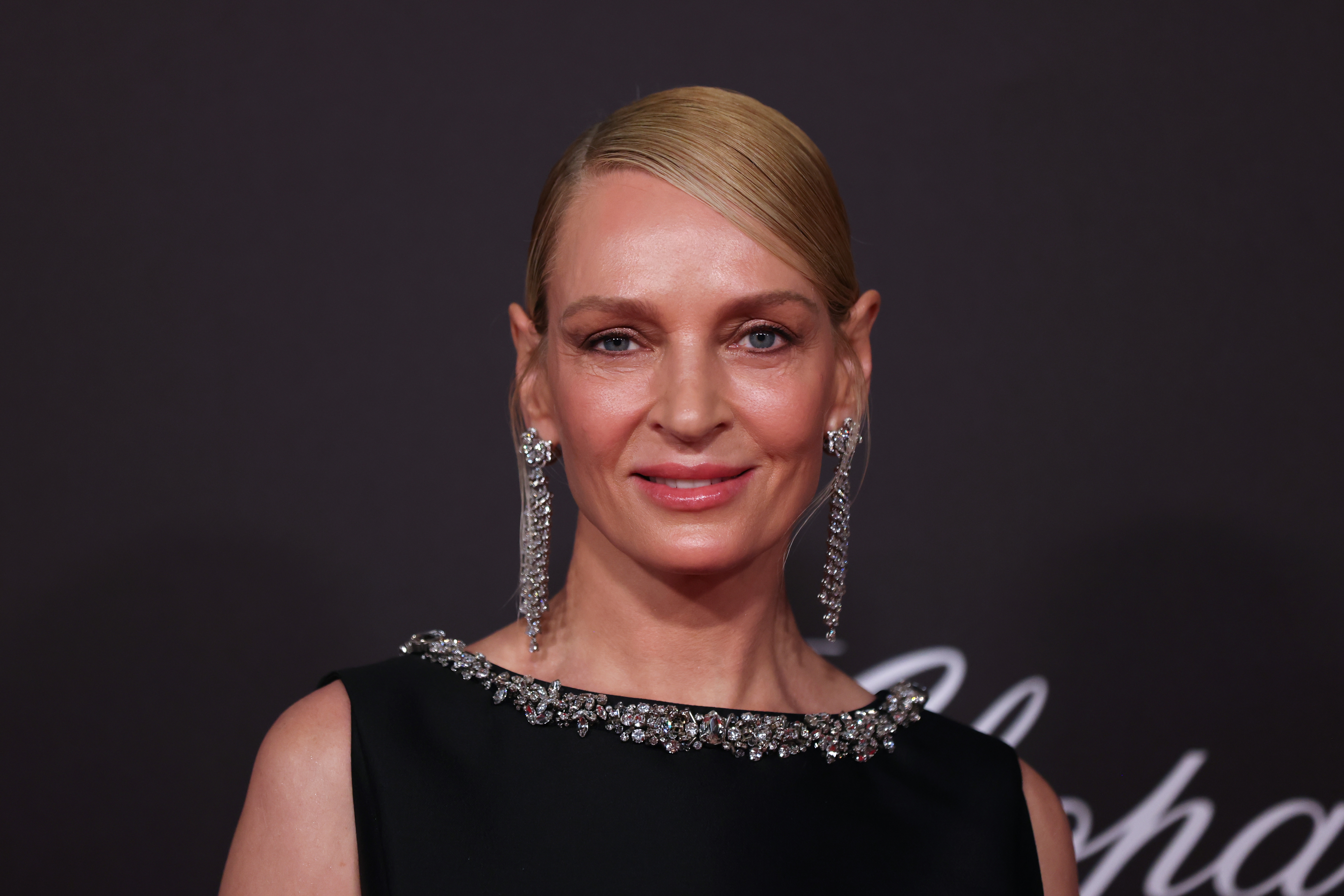 Person connected  reddish  carpet wearing a sleek achromatic  gown adorned with metallic  embellishments and agelong  metallic earrings, with hairsbreadth  neatly pulled back