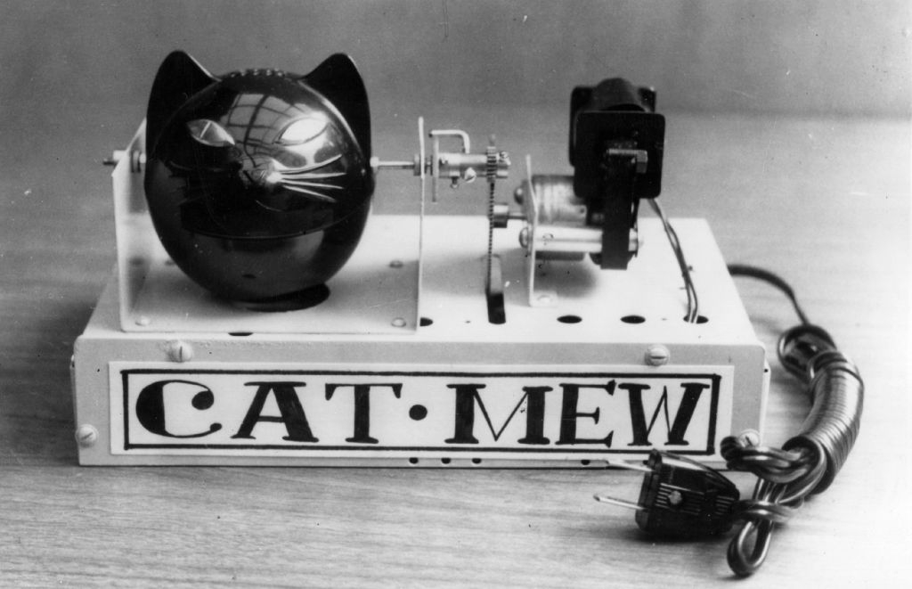 Vintage cat-shaped mechanical instrumentality  labeled "Cat Mew" with a powerfulness  cord, designed to mimic a cat's meowing sound
