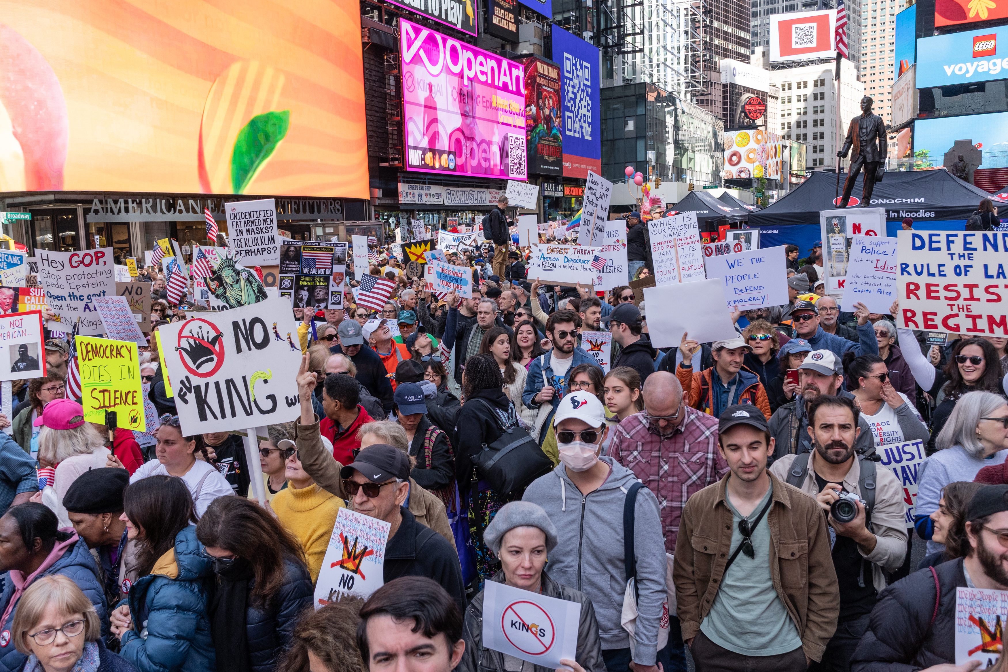 Crowd successful Times Square holding protestation signs astir ideology and governance, with radical of assorted ages and backgrounds participating