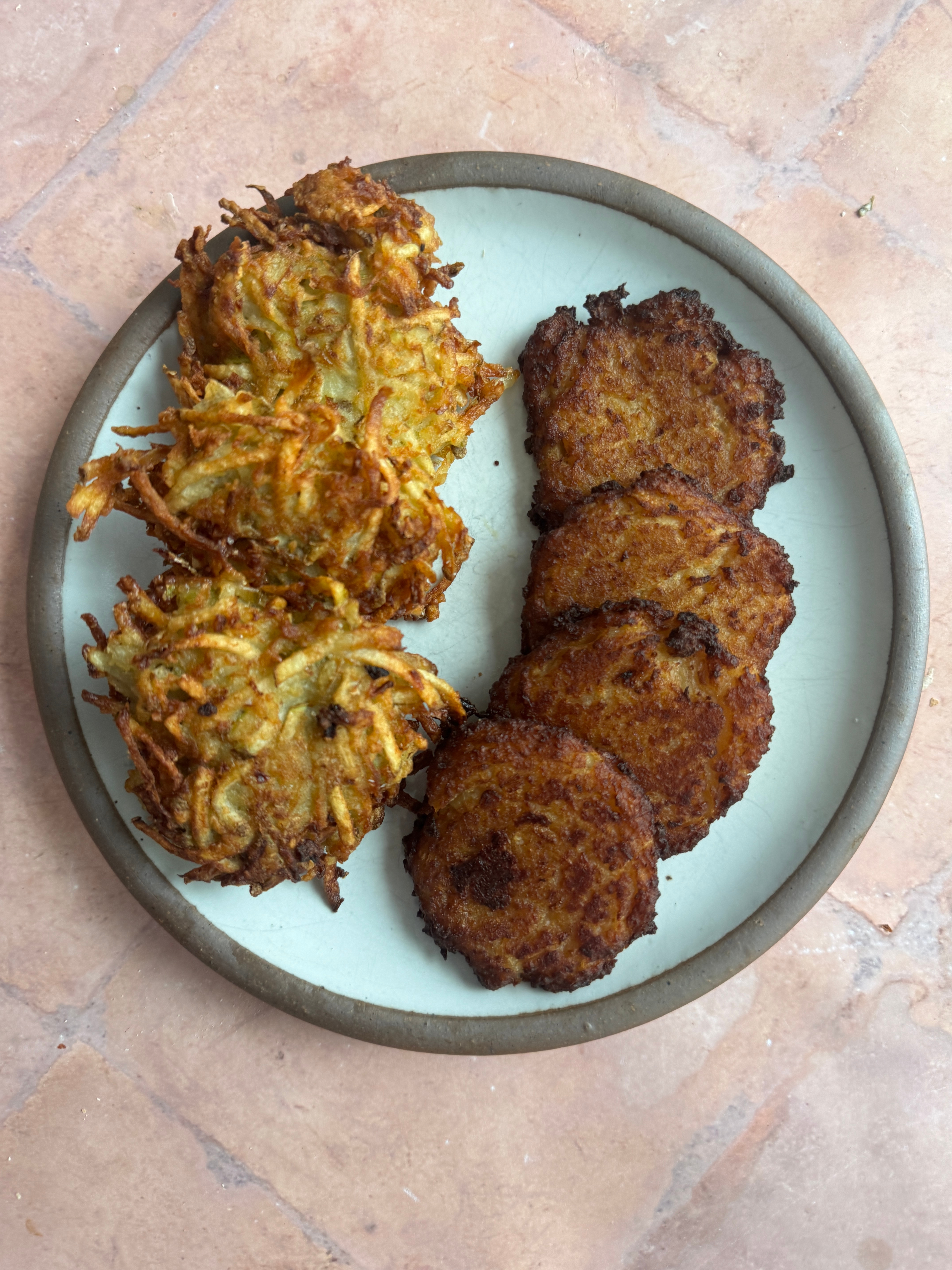 Plate with potato latkes, featuring two types: one with a shredded texture and another with a smooth, even surface