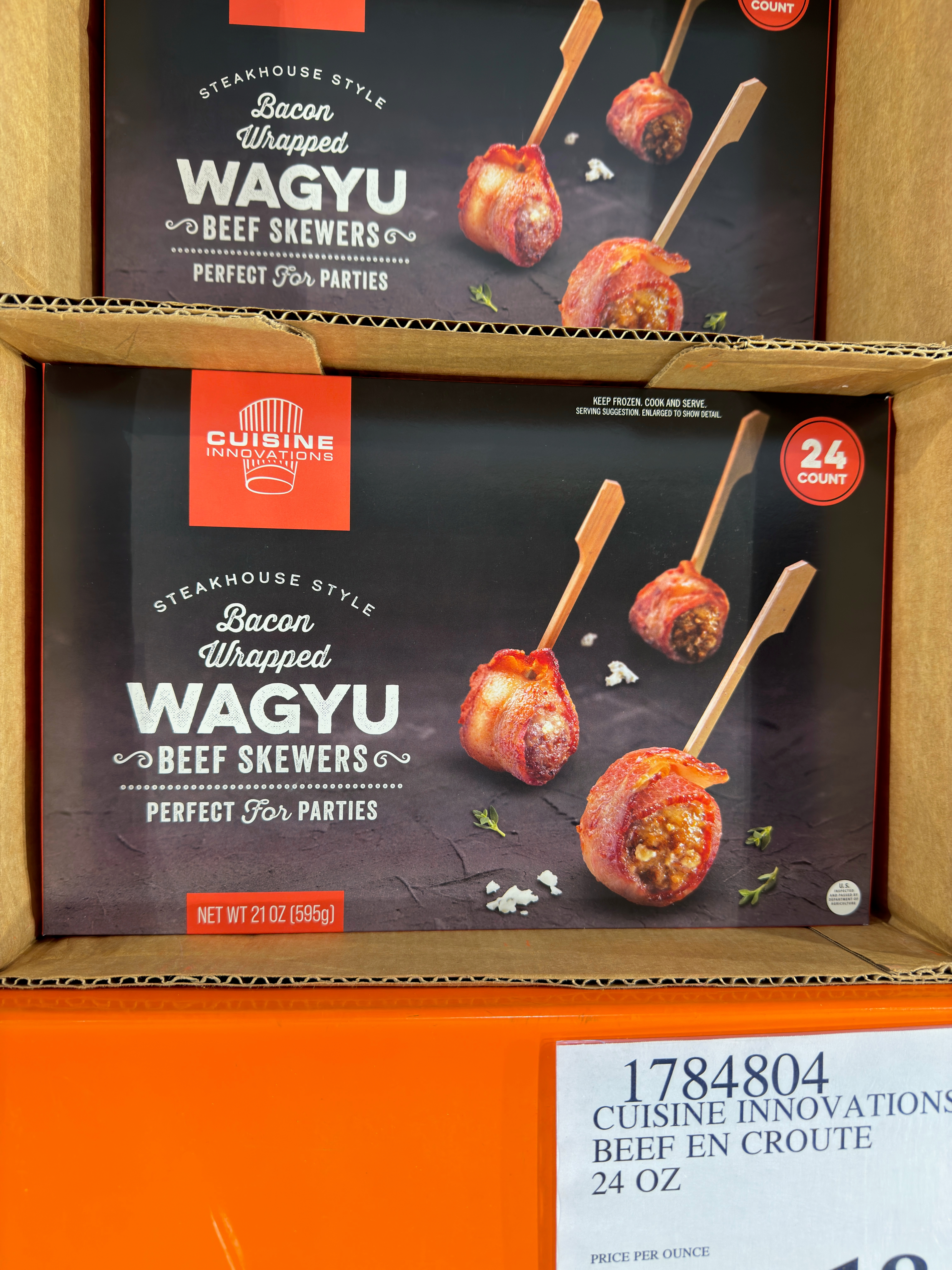 Boxes of bacon-wrapped Wagyu beef skewers with garlic and herbs, labeled "Perfect for Parties," displayed for sale