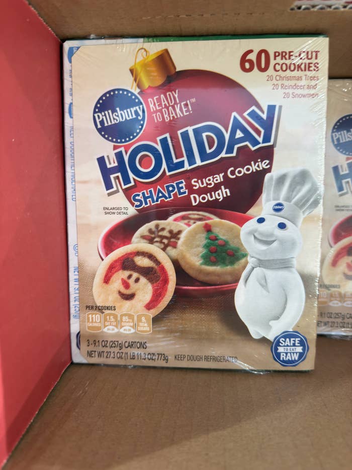 Pillsbury Holiday Shape Sugar Cookie Dough packaging with images of festive cookies and the Pillsbury Doughboy mascot