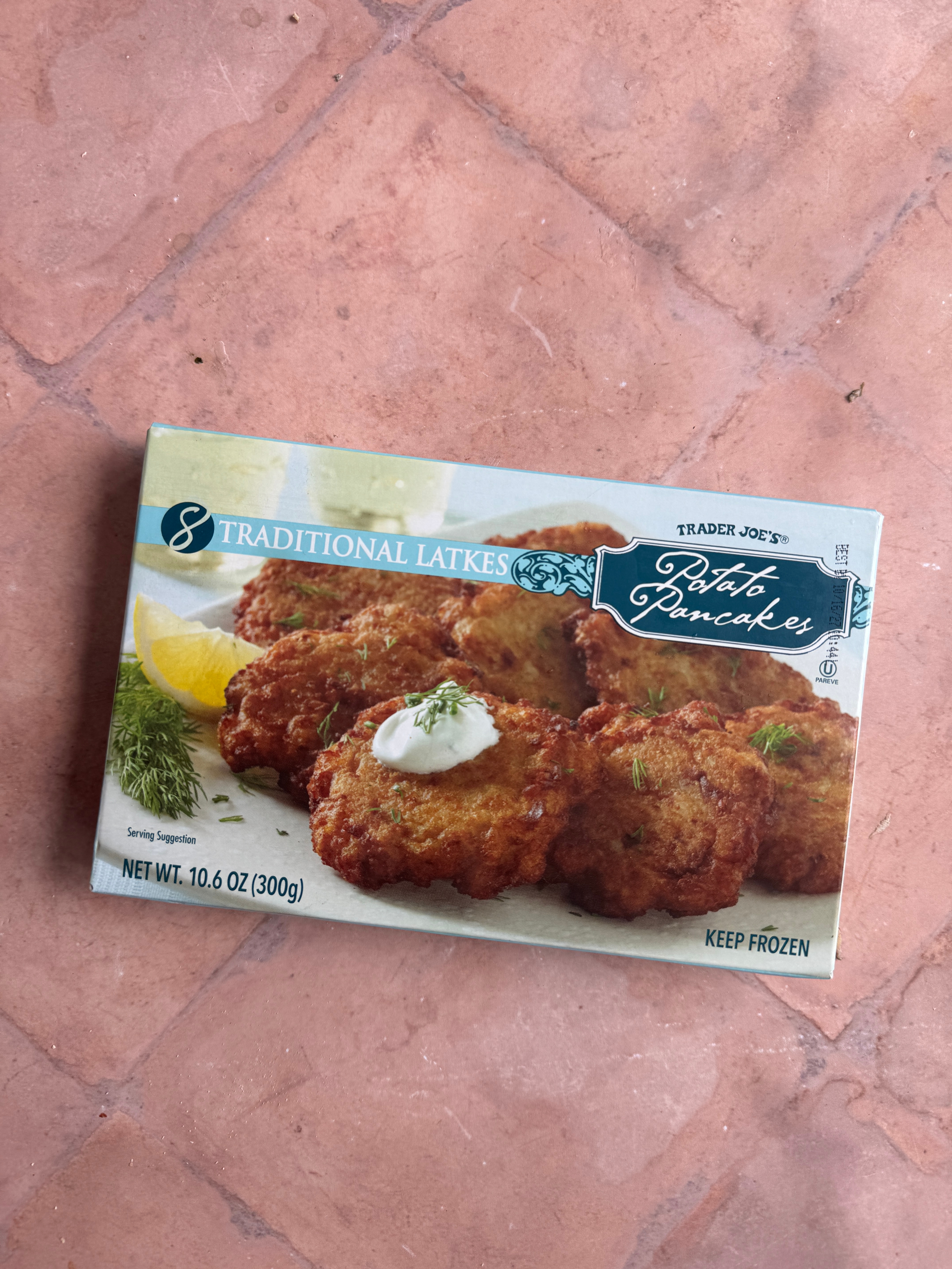 Box of Trader Joe’s traditional potato pancakes on a tiled surface
