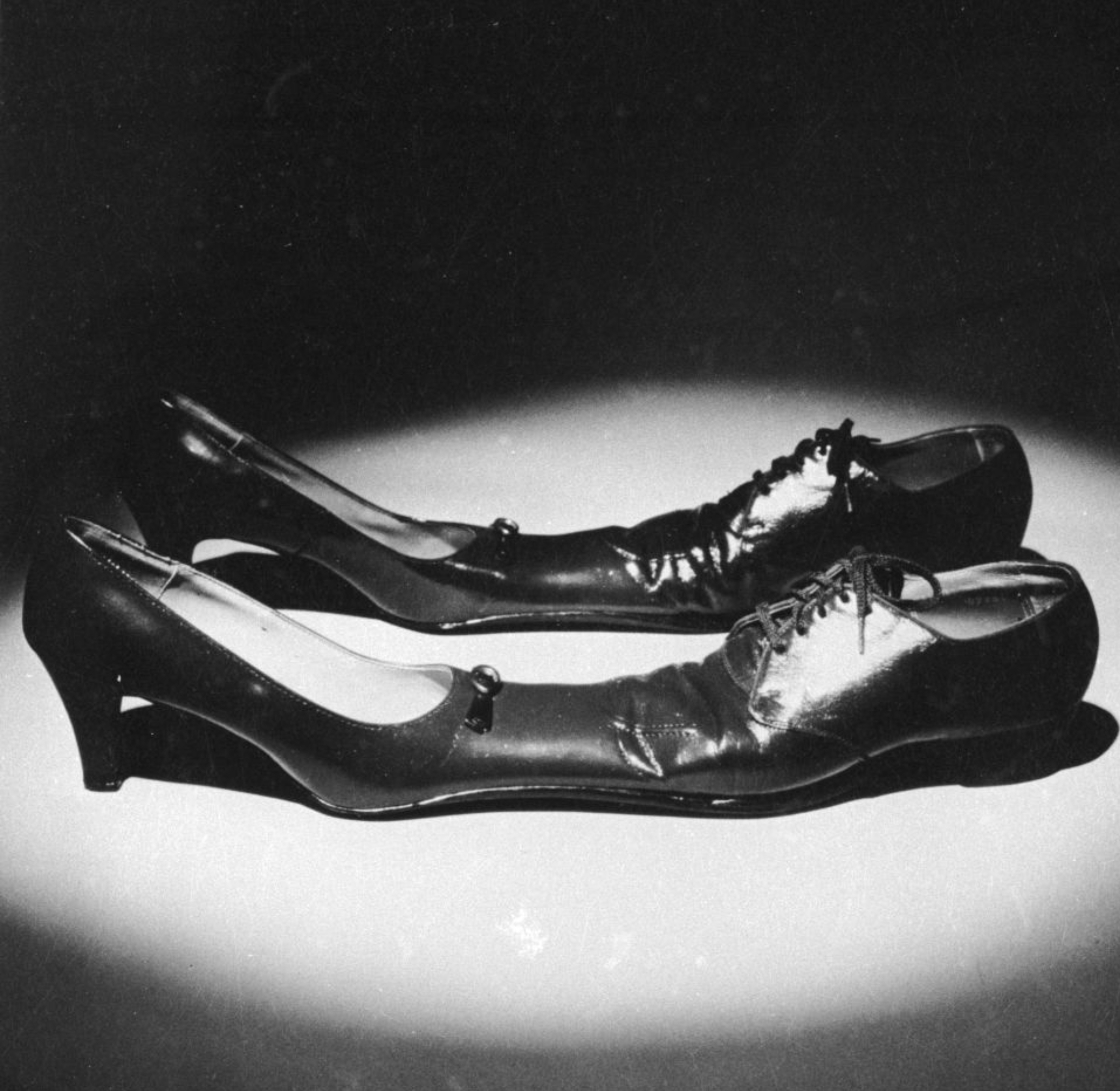 Two mismatched shoes, a precocious   bottommost   and a men's formal  shoe, placed unneurotic  nether  a spotlight connected  a plain surface