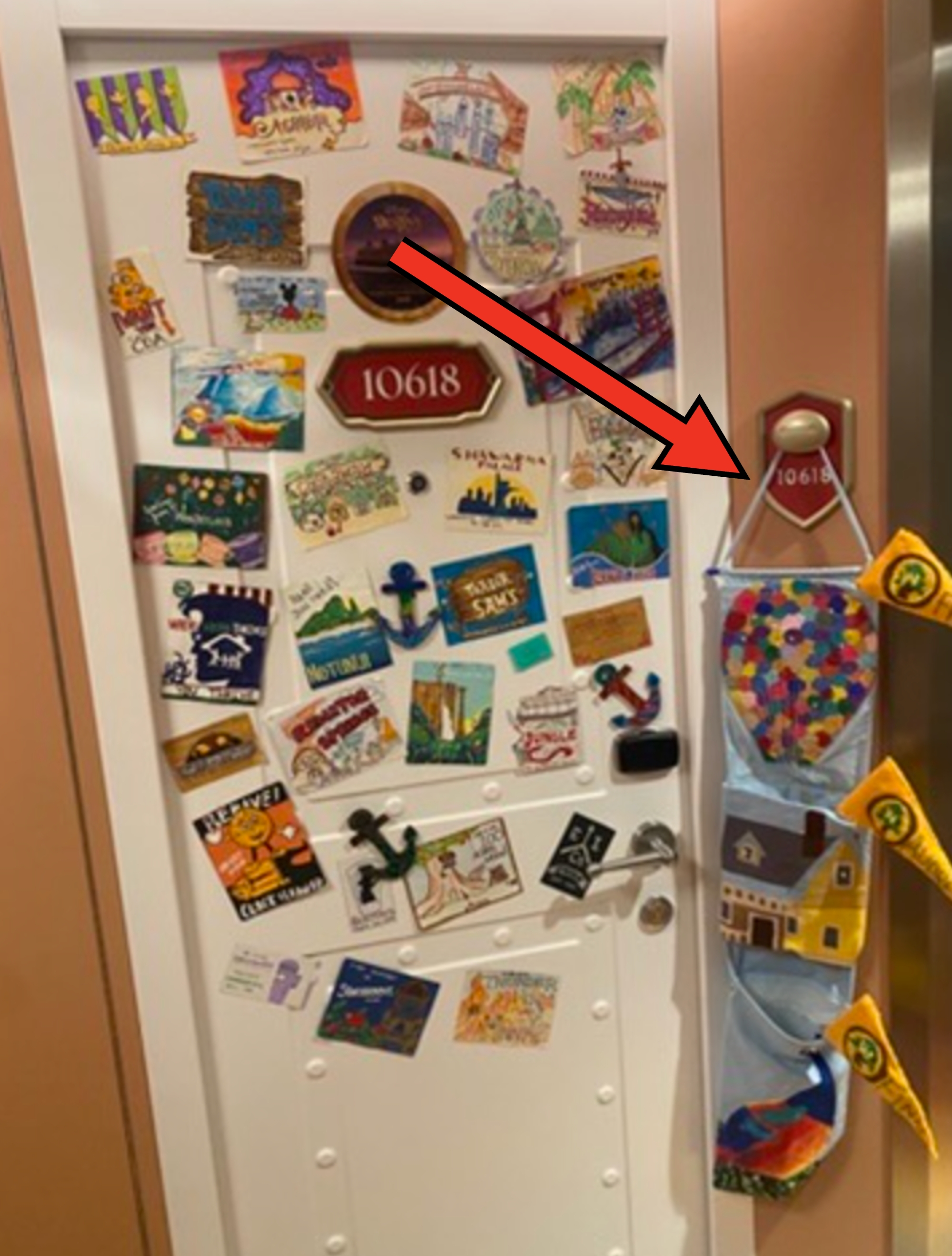 Door covered with colorful travel-themed magnets, cruise logos, and tiny  decorative flags, creating a personalized abrogation  display. Room fig   10618
