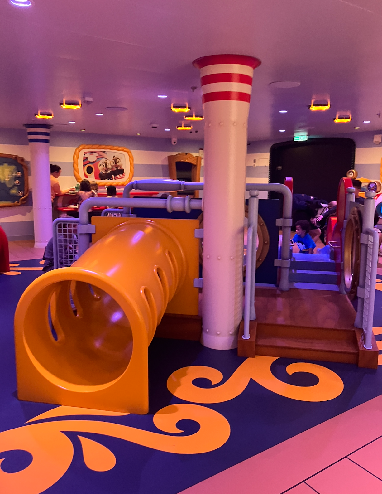 Indoor children's play   country  with play   tunnels and colorful nautical-themed decor. Children are playing nearby