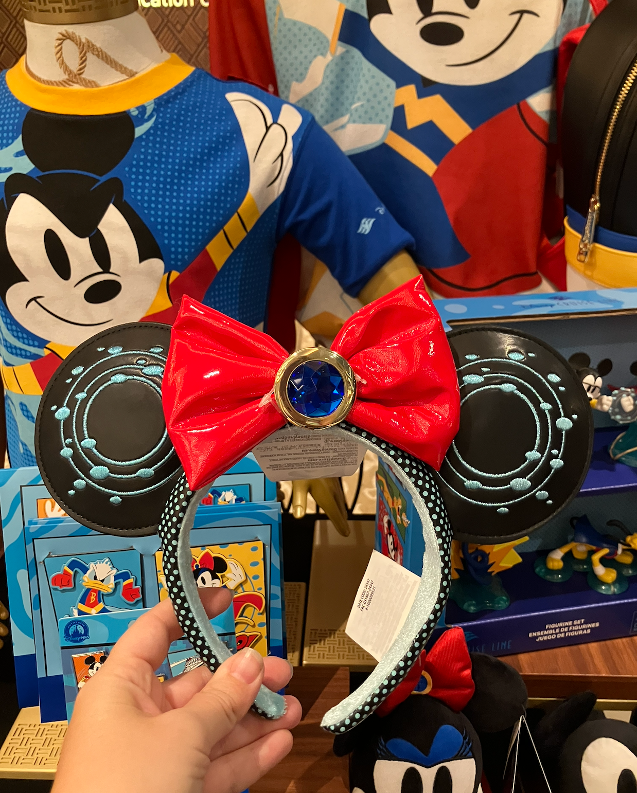Mickey Mouse merchandise show  featuring shirts and Minnie Mouse receptor  headbands with reddish  bows and bluish  accents