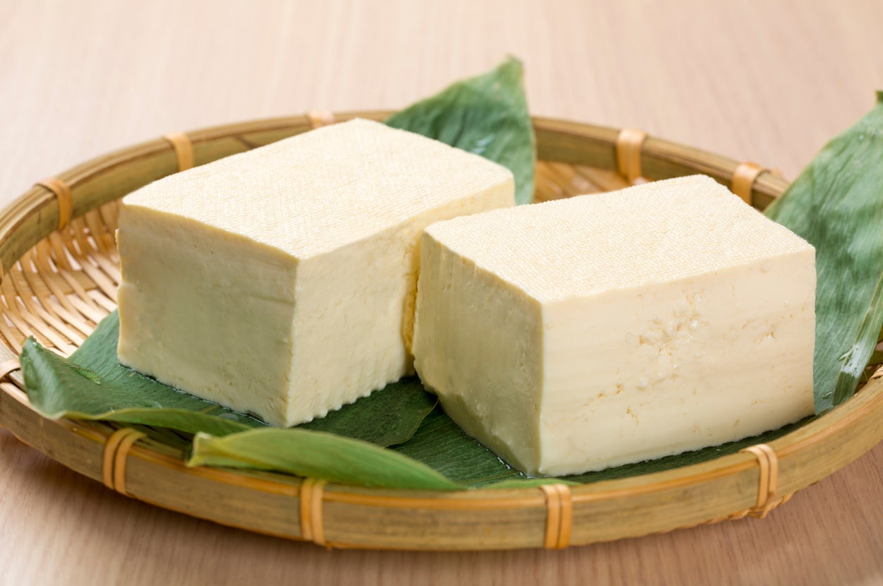 竹のざるに乗った2つの豆腐。