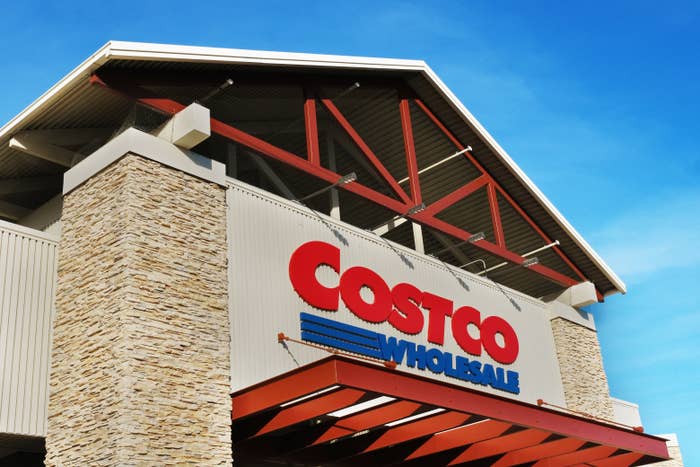 Costco Wholesale store exterior with large logo on building, featuring a stone facade and high roof