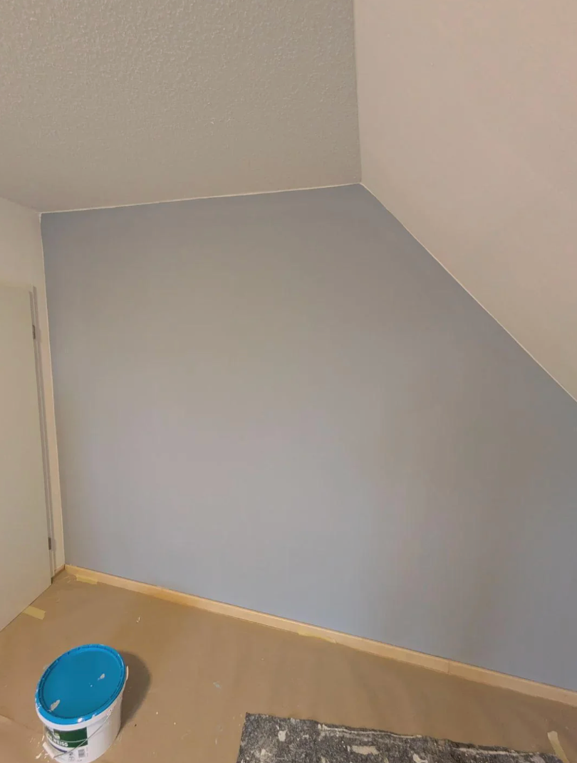 Room country   with angled wall, partially painted partition  with roller; overgarment   bucket connected  floor
